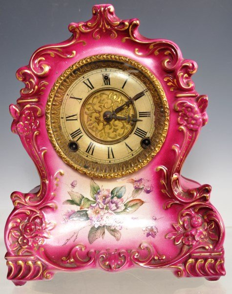 W.E. Gilbert Porcelain Mantle Clock: W.E. Gilbert porcelain mantle clock measuring 12"h; flow red glaze with hand painted floral design, gilt floral chaised face plate, marked #419 on reverse