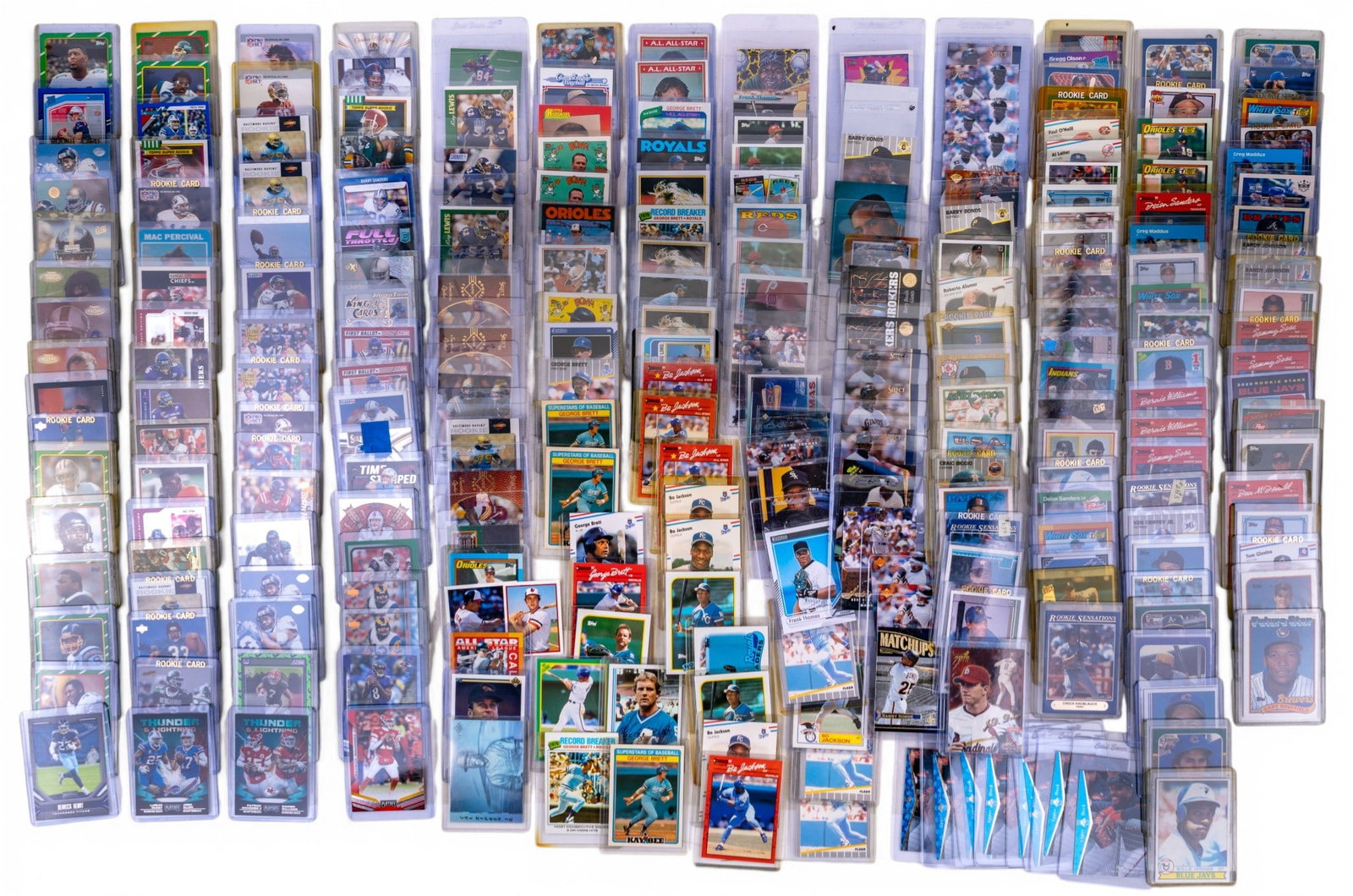 Sleeved Sports Trading Cards, NFL, MLB: Grouping of sleeved sports trading cards housed in sleeves featuring a mix of NFL and MLB players including rookies, Hall of Famers, and star athletes. Notable names include Reggie White, Bo Jackson,