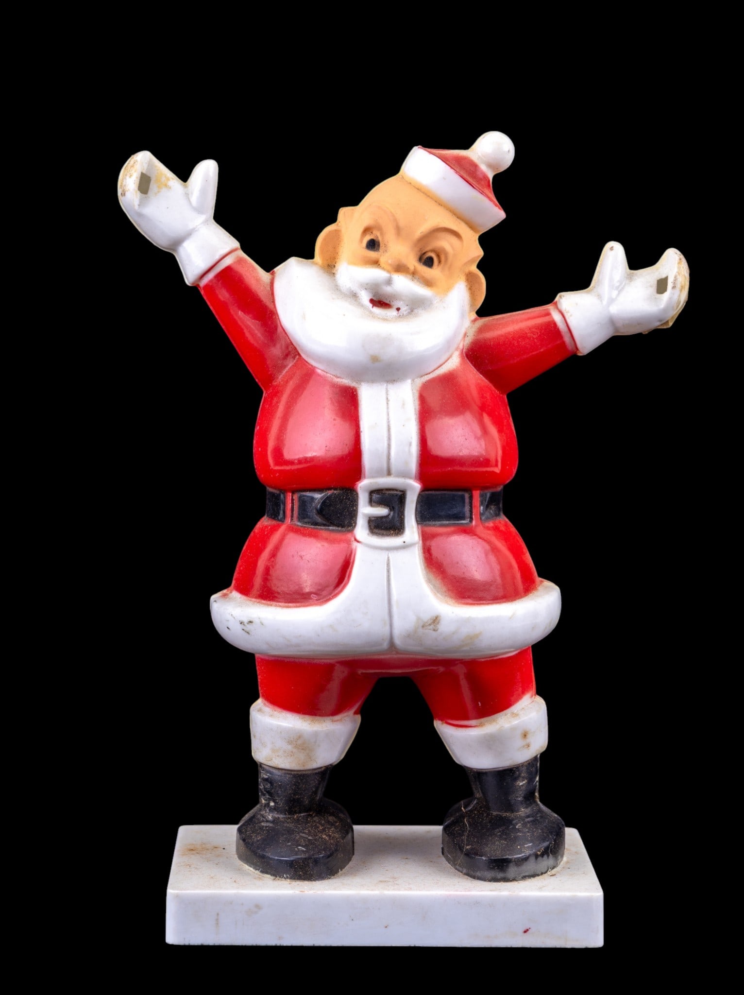 1950s Plastic Santa Candy Container: A 1950s-era Santa Claus candy container crafted from molded plastic. The figure features a classic red Santa suit, black boots, and white trim. The back includes an opening for holding candy or small