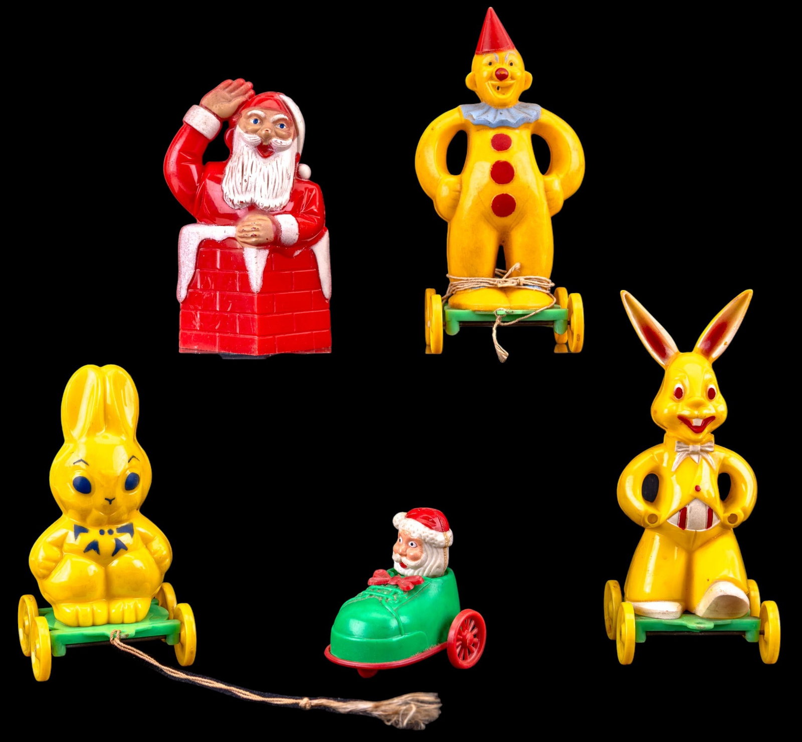 Vintage Hard Plastic Pull Toys, Candy Container: Mid-20th century hard plastic novelty toys including 3 pull-along wheeled figures, a small Santa in a shoe rolling toy, and a Santa candy container.