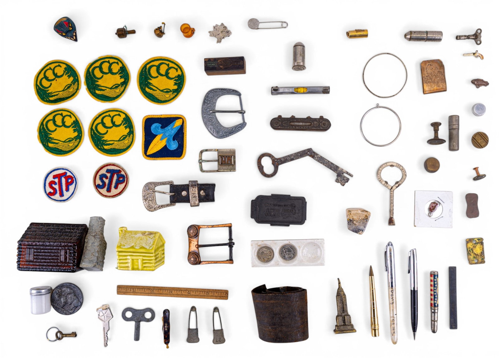 Men's Dresser Items and Tools: A collection of various men's dresser items including Avon Electric pre shave lotion in the figural log cabin bottle, a Sheaffer mechanical pencil, a 1935 Buffalo nickel, STP and other patches, teetot