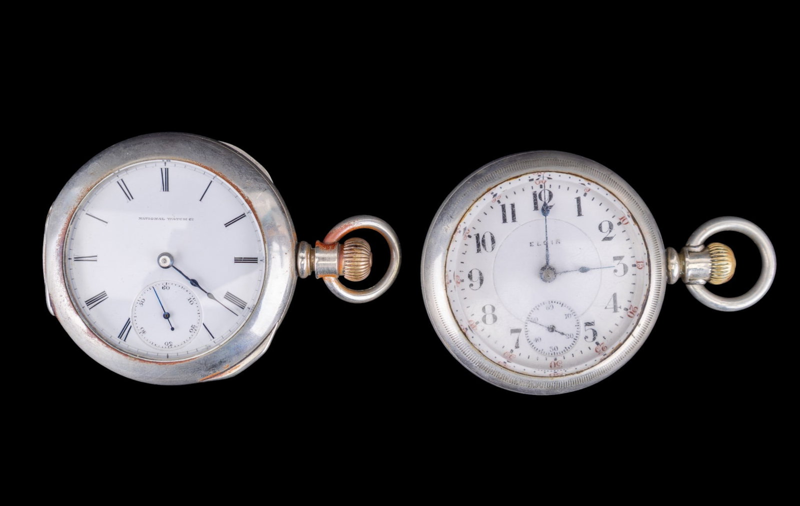 Elgin Pocket Watches: An Elgin pocket watch in a Fahys Oresilver twist off case with 1.875" porcelain dial and an Elgin movement with a 1.75" diam National Watch Co. porcelain dial in a Dueber Silverine case. Names and sty