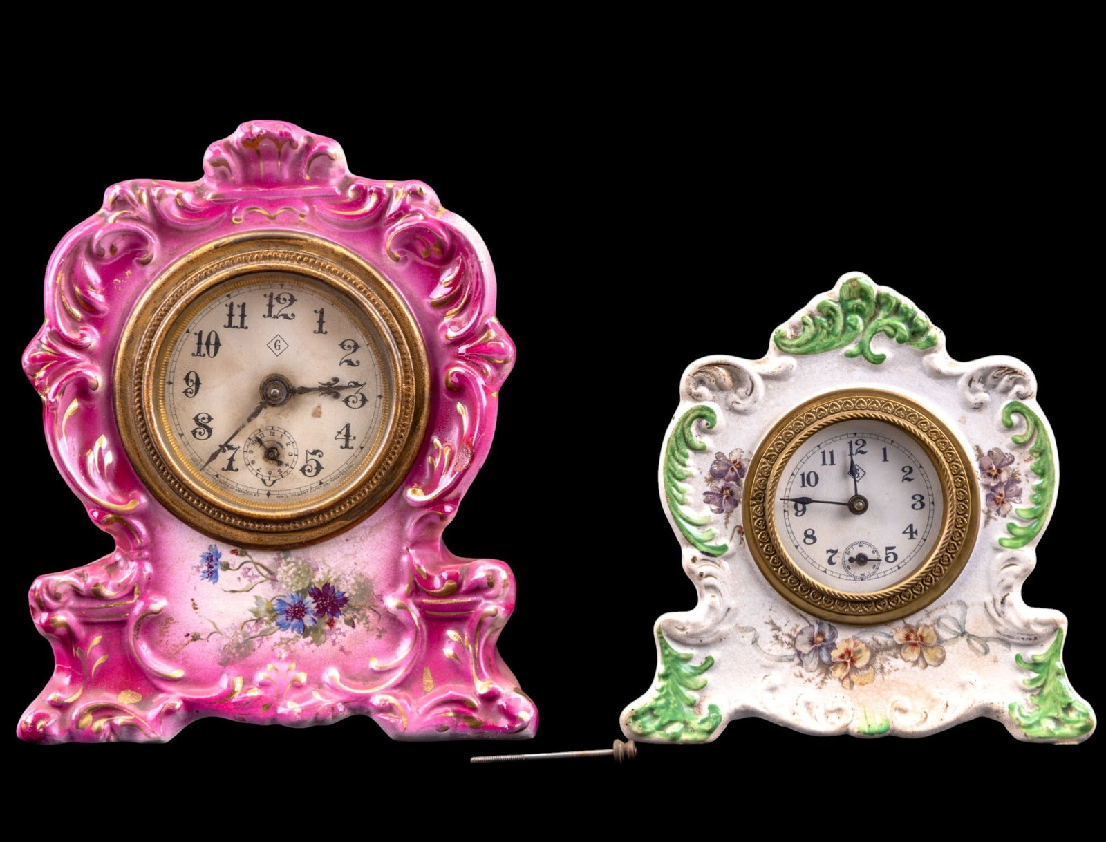Antique Gilbert Porcelain Mantle Clocks (2): Two small floral transfer painted porcelain case mantle clocks featuring wind-up Wm. Gilbert movements. The pink and floral clock is marked "Lily" and it measures approx. 6.25" W x 3" D x 8" H, (will