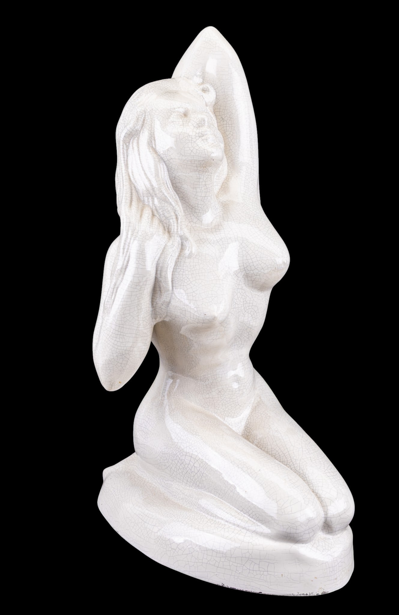 Ceramic Crackle-Glaze Nude Female Sculpture: Decorative ceramic sculpture depicting a kneeling female nude figure with one arm raised behind the head. Finished in a cream crackle glaze. Unmarked. Measures approx. 22.25" H.