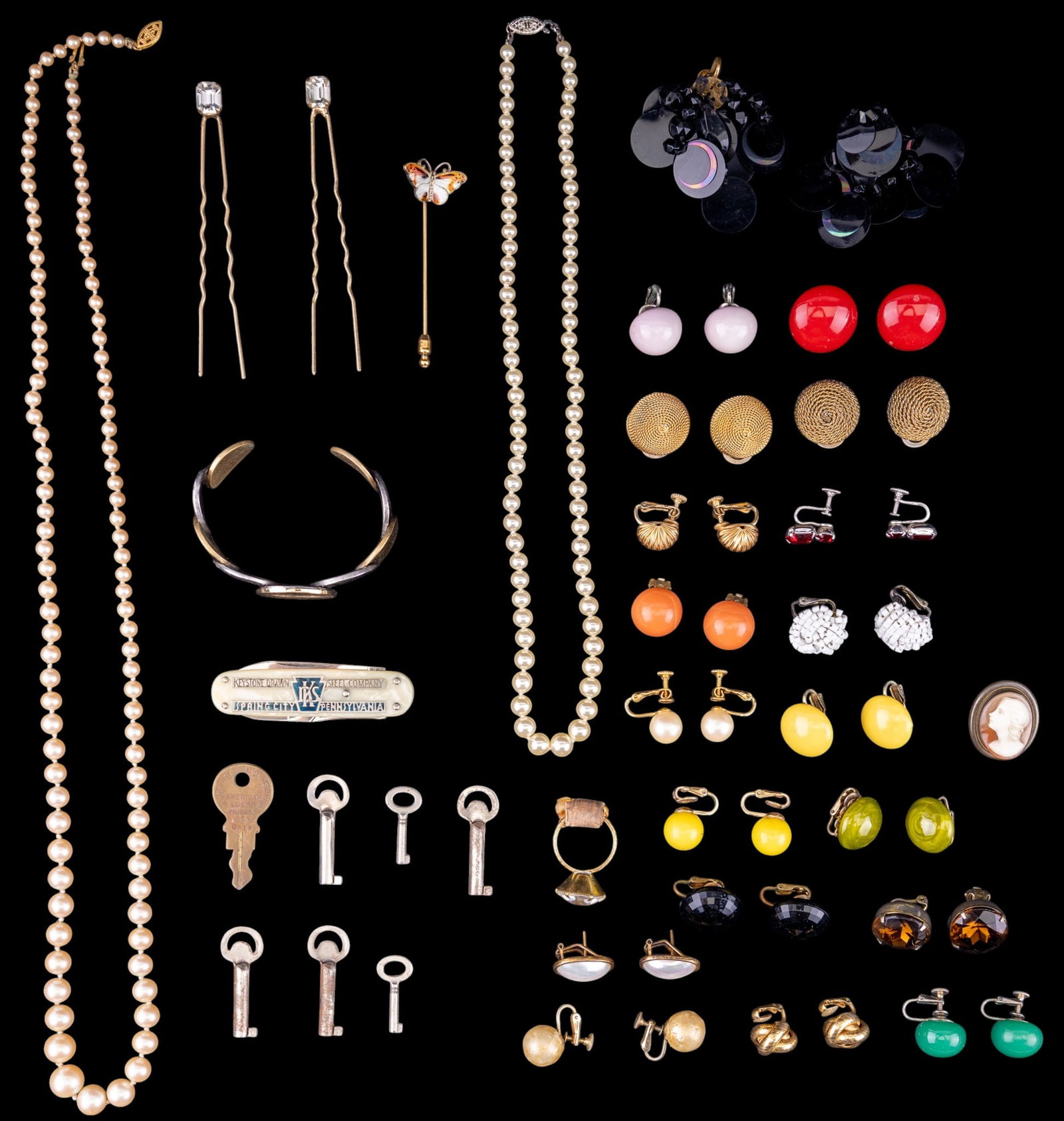 Variety of Vintage Jewelry: Includes a cuff bracelet made of foreign coins, a large variety of clip earrings, pearl necklaces, and more.