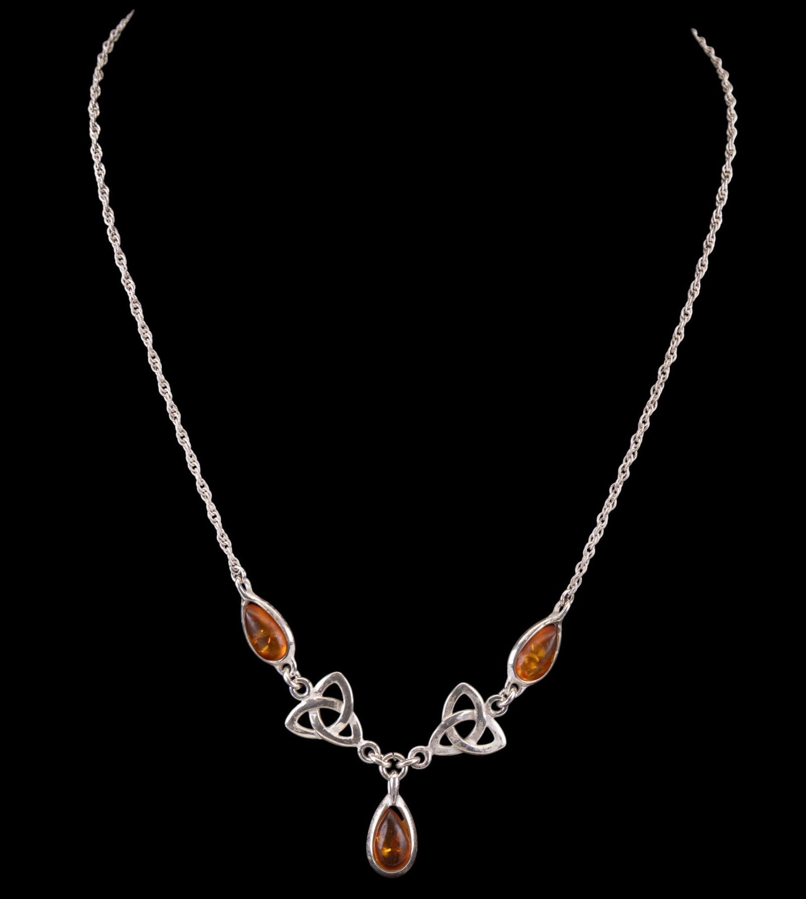 Celtic Amber & Sterling Necklace: Sterling silver necklace set with amber and displaying celtic symbols.