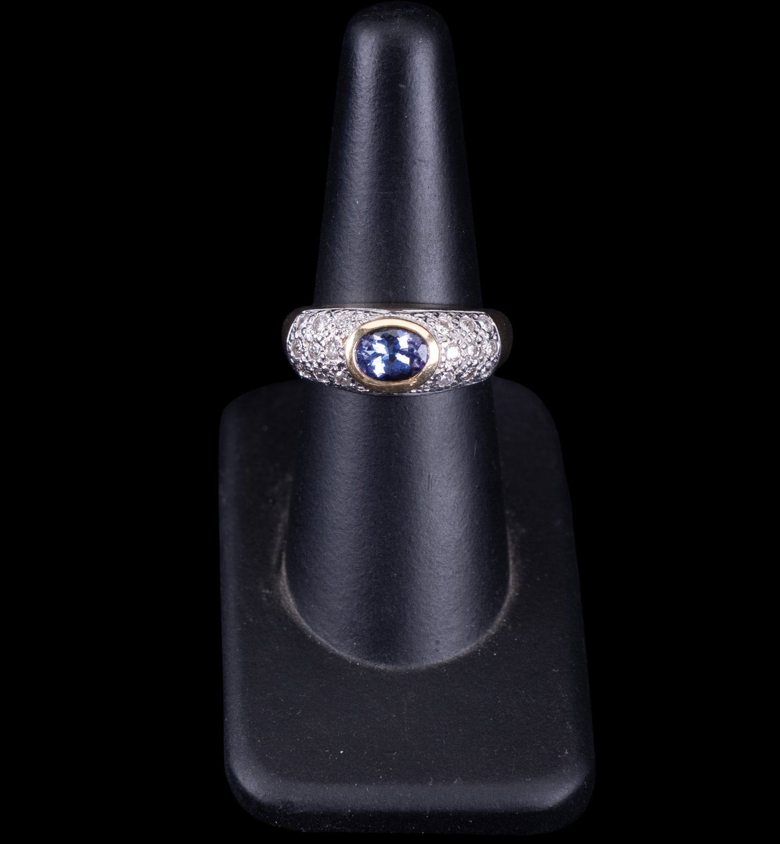 14K Gold Tanzanite Diamond Ring: A 14K gold ring featuring an oval brilliant cut tanzanite with diamond accents, size 7, tanzanite measures approx. 5x7mm, and weighs approx. 7.2g.