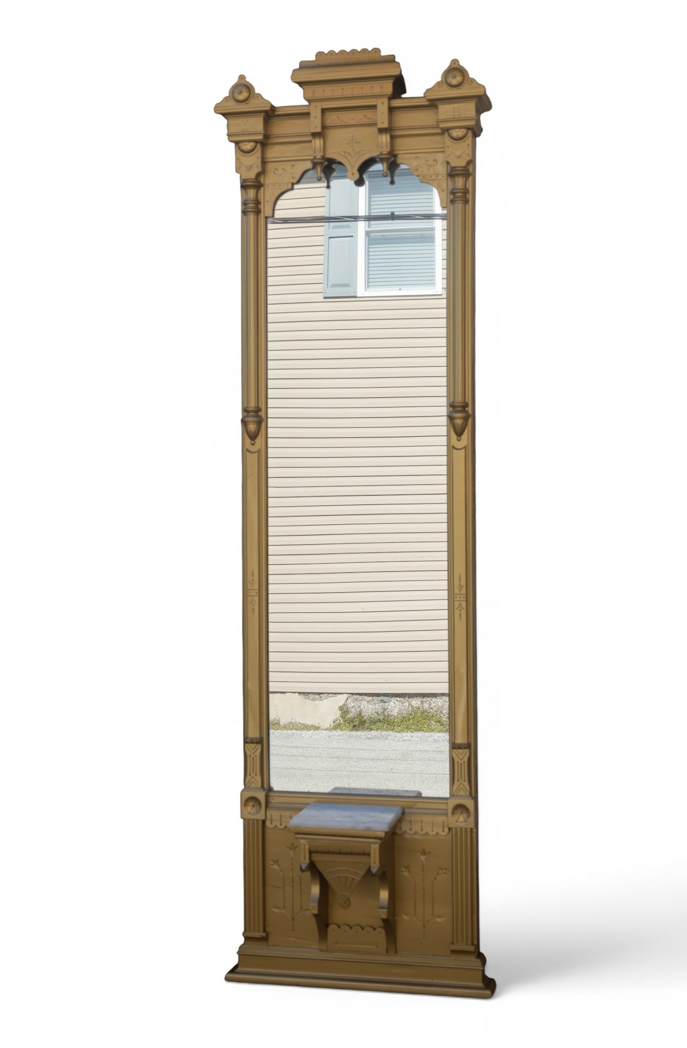 Gold Painted Mirror with Marble Shelf: Tall gold-painted mirror with an ornate wooden frame, featuring carved details and decorative finials. Includes a small rectangular marble slab shelf beneath the mirror. The piece appears suitable for