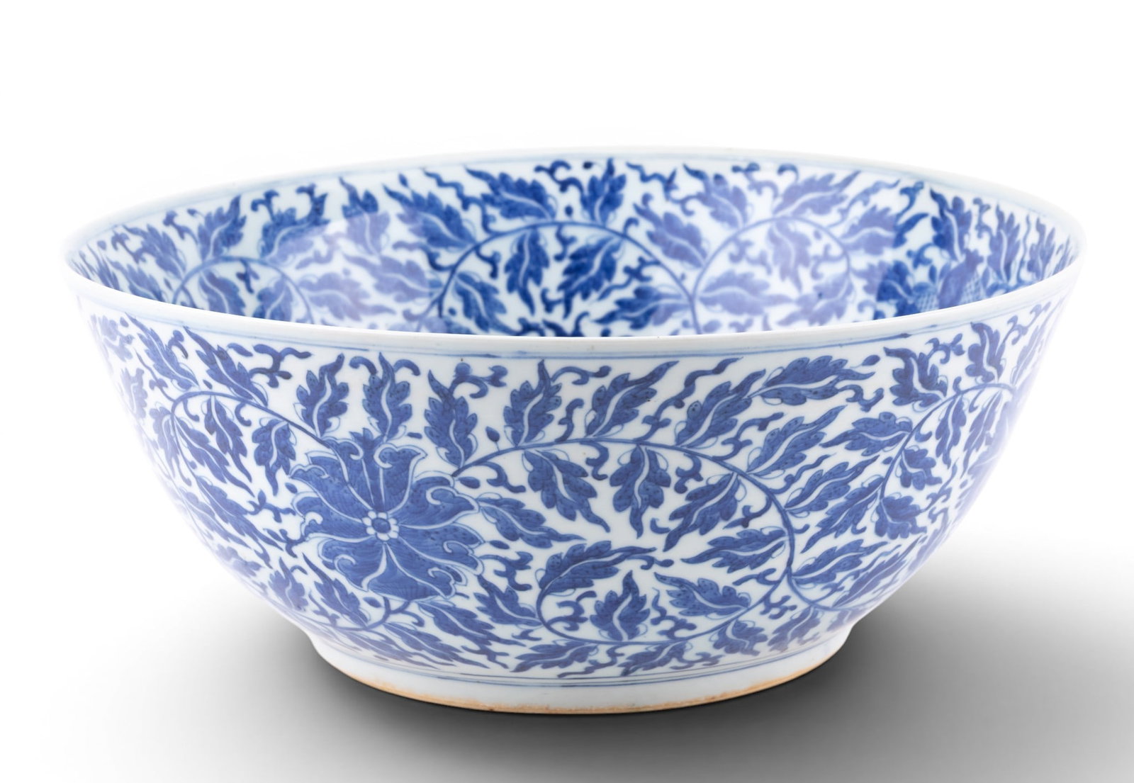 Large Chinese Blue & White Porcelain Bowl: Large Chinese porcelain bowl decorated in under glaze blue with dense scrolling floral and foliate motifs throughout the interior and exterior, centered by a stylized blossom medallion. Underside bear