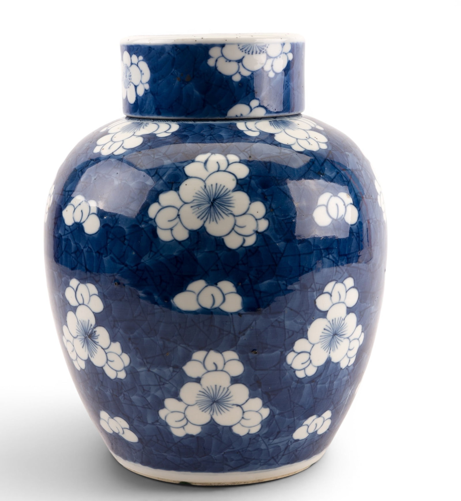 Chinese Blue & White Ginger Jar w/ Porcelain Lid: Chinese porcelain ginger jar of globular form, decorated in under glaze blue with prunus blossom reserves on a cracked-ice ground. Retains matching porcelain lid. Underside bears a double blue ring ma