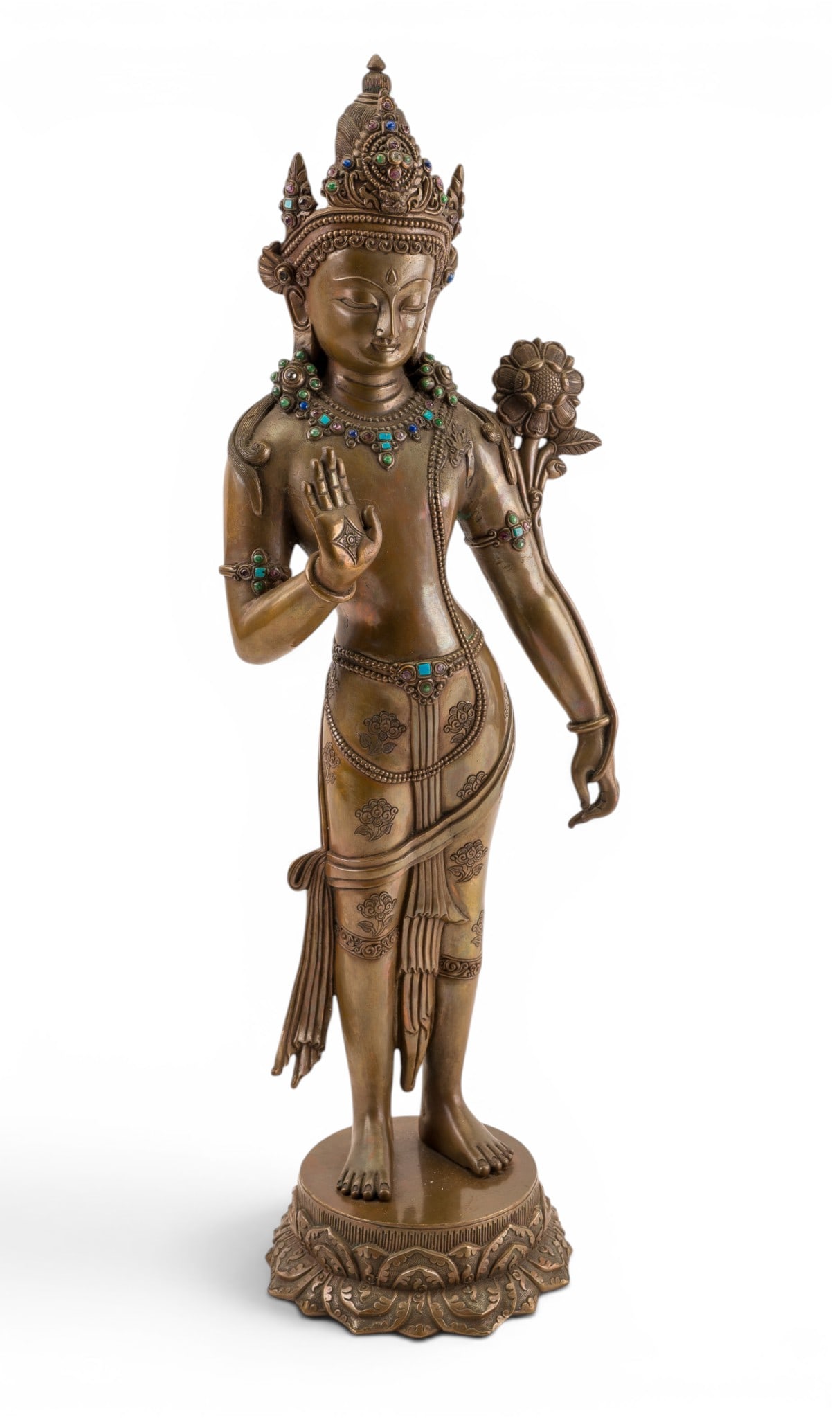 Bronze Jeweled Standing Tara Figure: Bronze figure depicting Tara, shown standing on a lotus-form base and adorned with elaborate jewelry and headdress set with turquoise and other colored stones. Figure holds a lotus blossom at shoulder