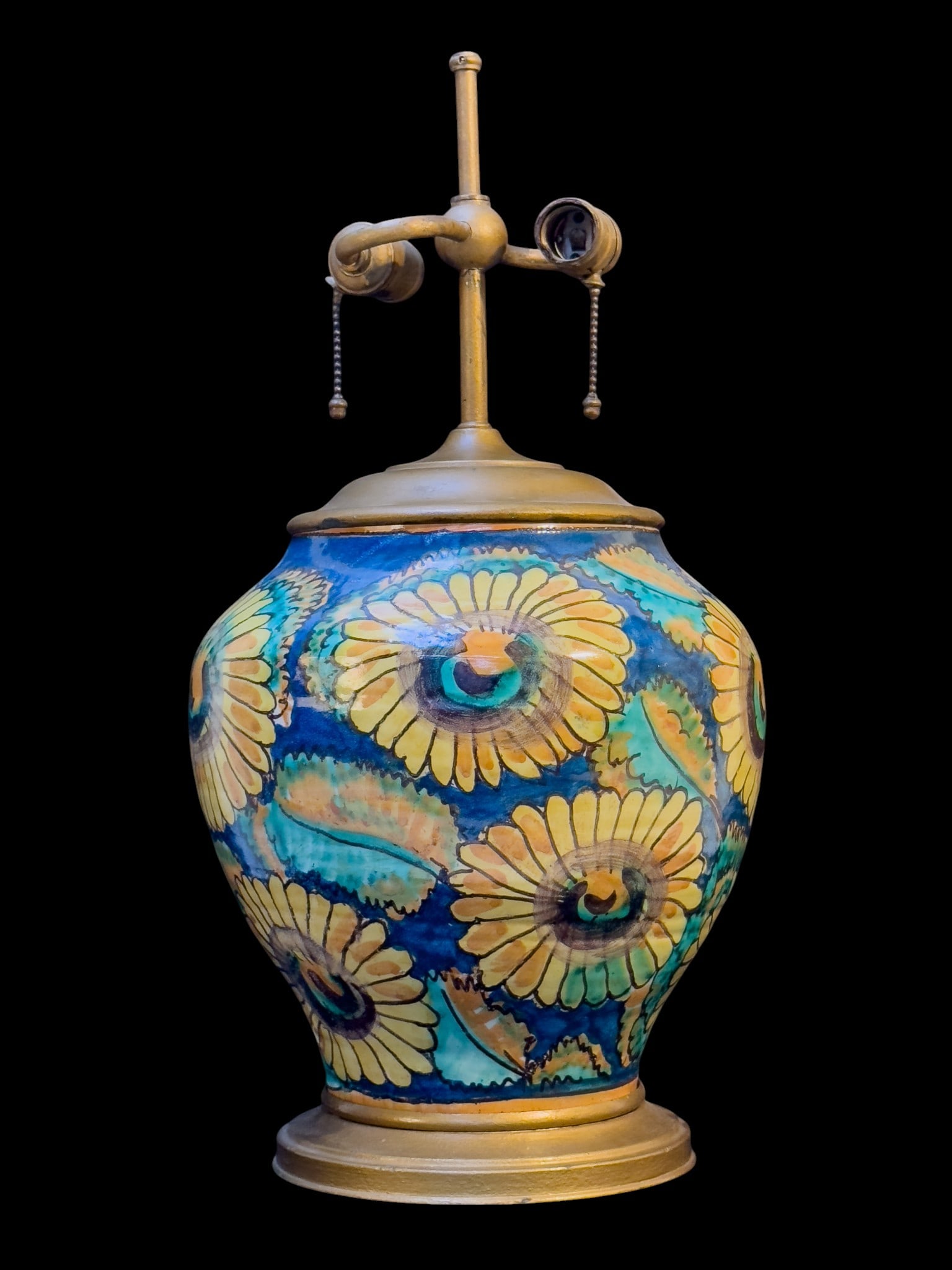 Hand Painted Earthenware Table Lamp: Vintage earthenware table lamp featuring a bulbous ceramic body decorated with hand painted floral motifs in yellow against a blue ground. Fitted with metal mounts. Measures approx. 21" to top x 9" di