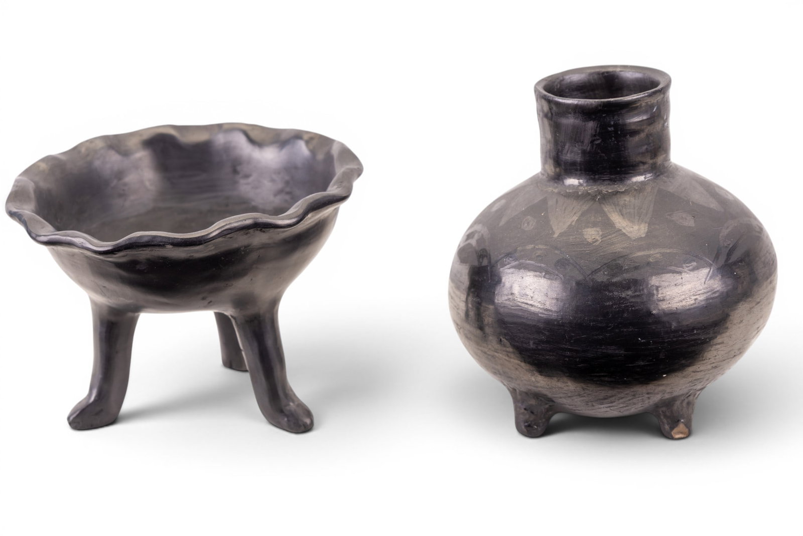 Oaxaca Barro Negro Pottery: A collection of Barro Negro pottery from Oaxaca, Mexico including a tripod bowl featuring a ruffled rim (approx. 6" diam x 4.5" H), and a footed vase/jar (approx. 6" H).