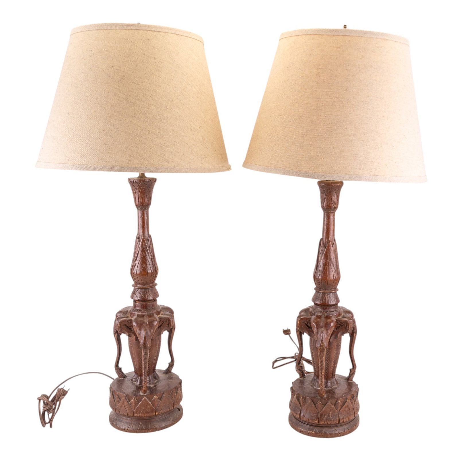 Mid Century Carved Wood Elephant Lamps: A matching pair of mid century carved wood figural elephant lamps. Note lamp bodies come apart in the center. Harps are marked 'Chilo'. Both measure approx. 23" H to the socket, 31" H to the finial. U