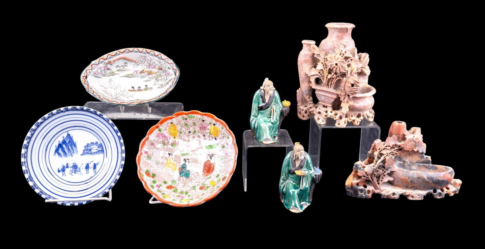 Asian Soapstone Figures, Porcelain, Mud-Men: Grouping includes two soapstone carved vessels / figures (larger measures approx. 6.5" high), a 6" blue and white plate, 6.5" shallow bowl, and 7" wide ovular plate. Also included are two Chinese mud