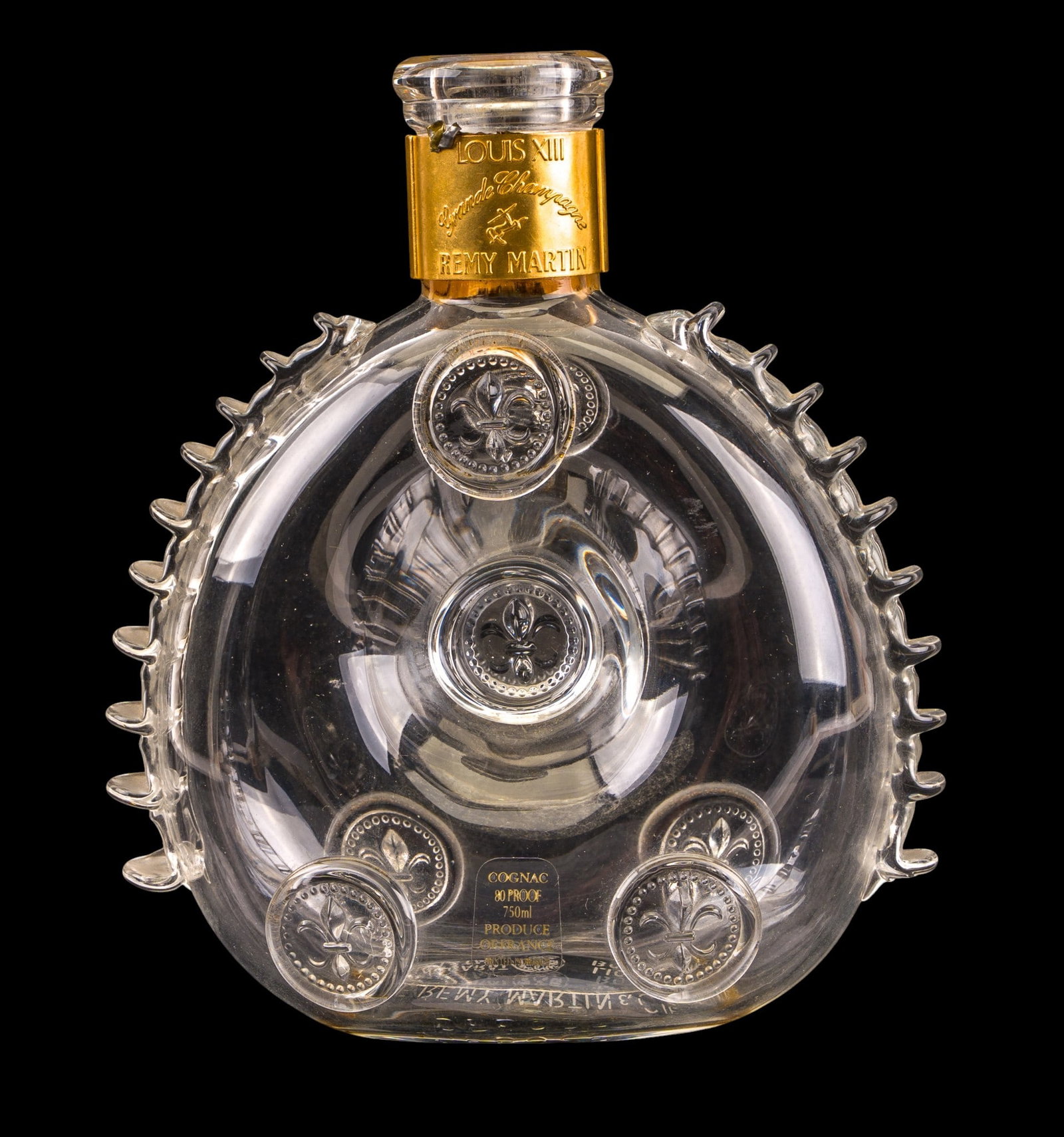 Baccarat Crystal Louis XIII Remy Martin Decanter: Rare Baccarat crystal decanter produced for Remy Martin Louis XIII cognac, featuring rounded form with applied medallions and a fleur-de-lis stopper. Retains gilt metal collar marked "LOUIS XIII Grand