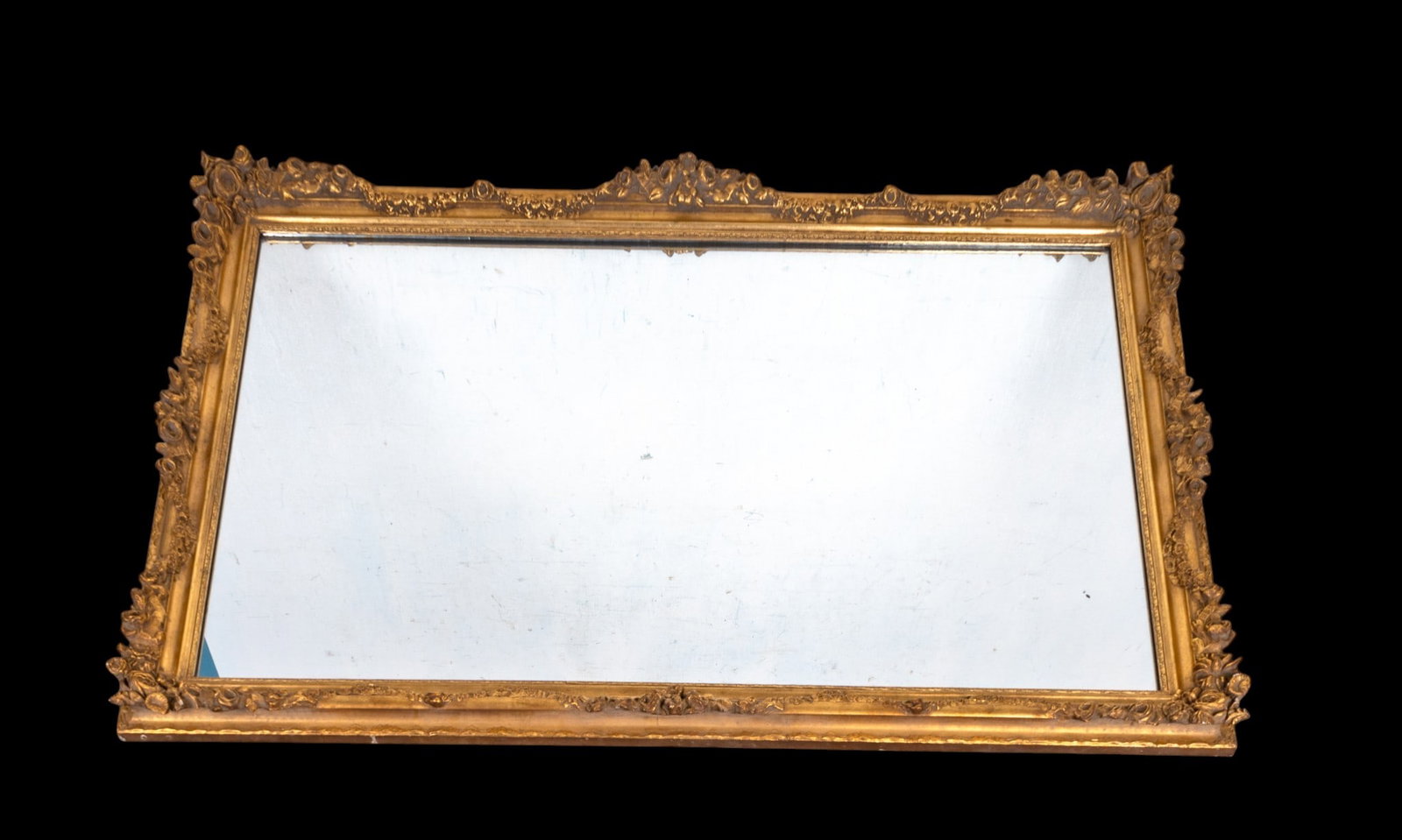 20th C Decorator Gilt Wood Hart Mirror: A 20th Century decorator gilt wood mirror from Hart Mirror Plate Company, with raised floral embellishments. Measures approx. 36.5" H x 54" H. Item is in very good condition.