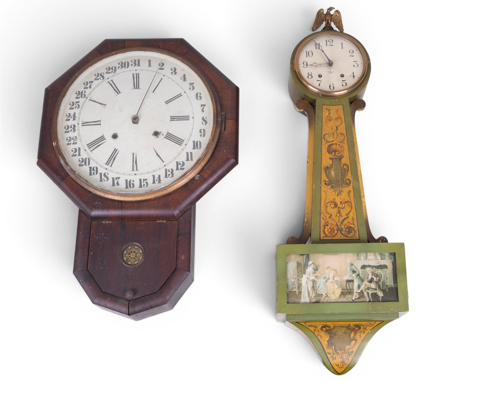 2 Gilbert USA Wall Clocks: 2 William L. Gilbert Clock Company Wall Clocks. First a painted green case example with gilt stencil decoration, eagle finial, and painted figural glass door. Second an octagonal wood case clock with 