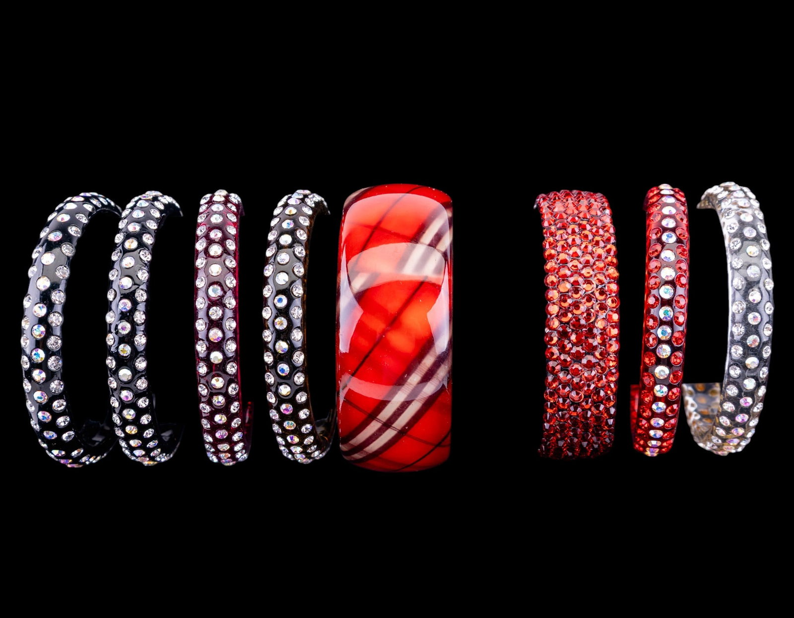 Rhinestone Bracelets: Includes 7 colored plastic and rhinestone bracelets, as well as a wide red plastic bangle.