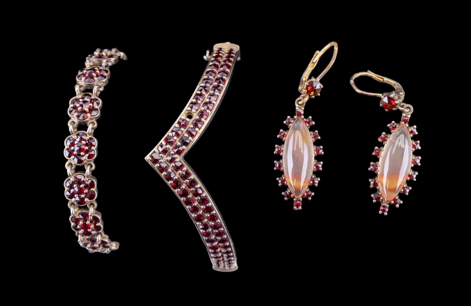 Antique Garnet Jewelry: Includes a silver garnet hinged bangle with hallmarks, an early "panel" garnet bracelet made of silver, and a pair of elongated silver quartz and garnet earrings.