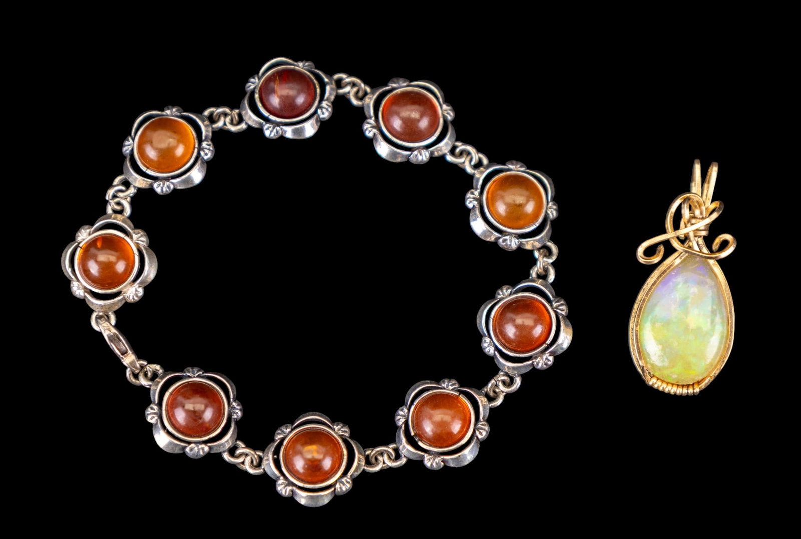 Opal Pendant and Amber Bracelet: Large opal pendant set in gold-tone wire and a sterling silver and Baltic amber bracelet.