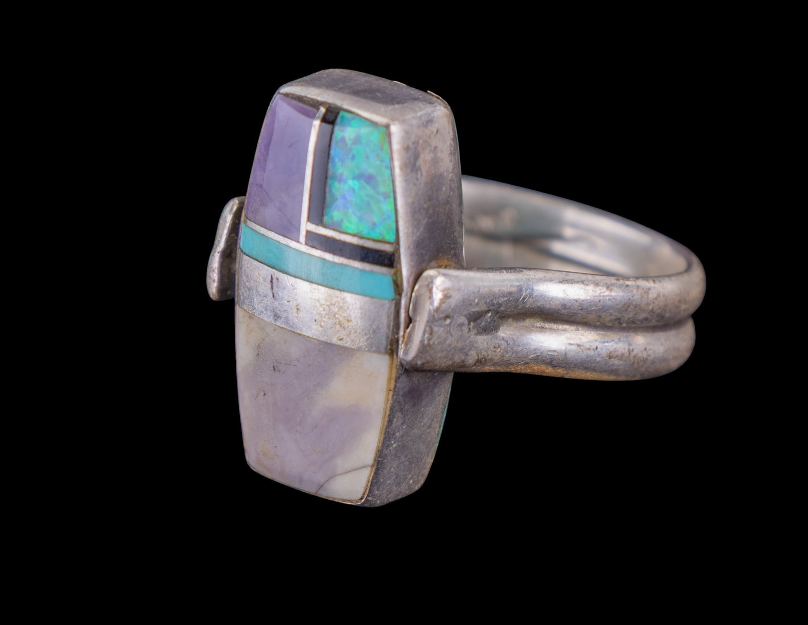 Native Flip Ring: Sterling marked and maker signed N.A. "flip" ring inlaid with turquoise and opal on one side, and mother of pearl and purple stone on the reverse.