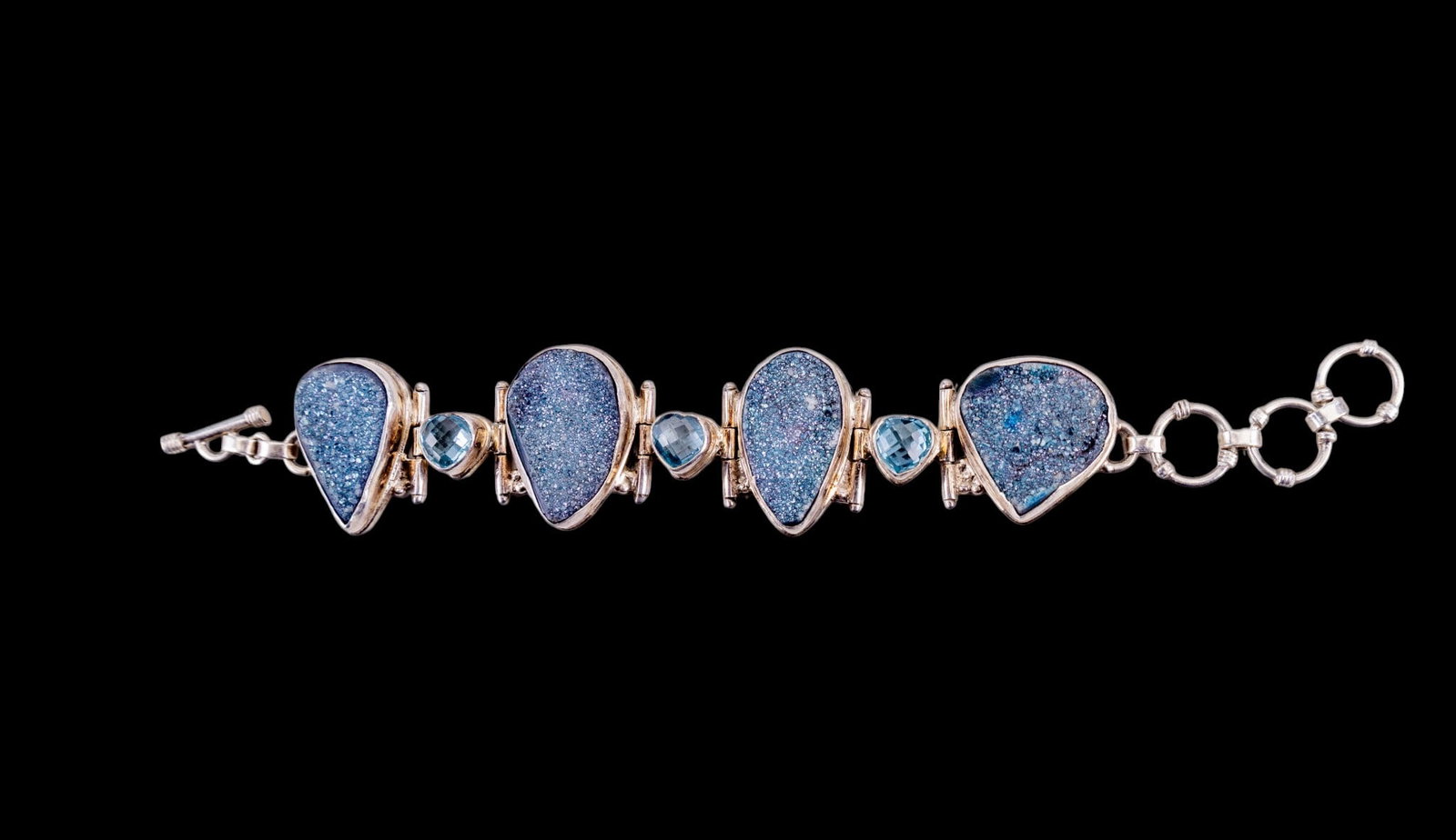 Sterling and Druzy Bracelet: Large .925 sterling silver bracelet set with 4 large druzy stone pieces and 3 heart shaped cushion cut topaz stones
