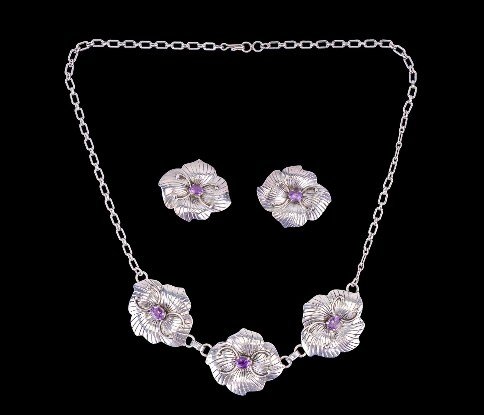 Carol Felley South West Jewelry: Circa 1985 signed Carol Felley sterling silver "hibiscus" set with amethyst stones, with large matching earrings.