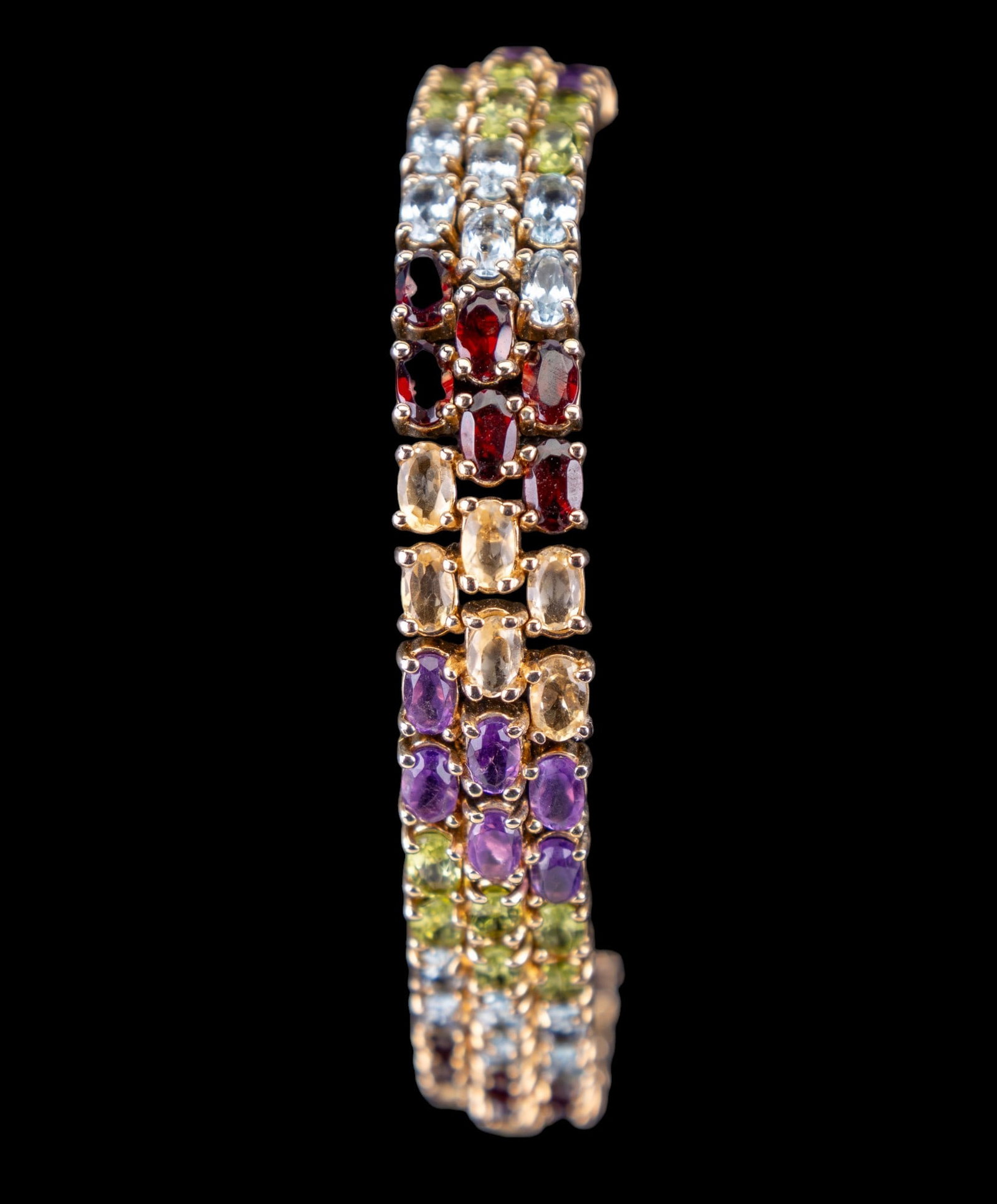 Gemstone and Sterling Silver Bracelet: Sterling Silver bracelet set with semi-precious stones to include garnet, citrine, amethyst, peridot and aquamarine.