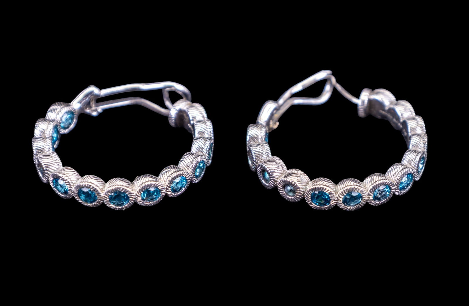 Judith Ripka Sterling Earrings: Sterling Silver designer Judith Ripka hoop earrings with blue stones.