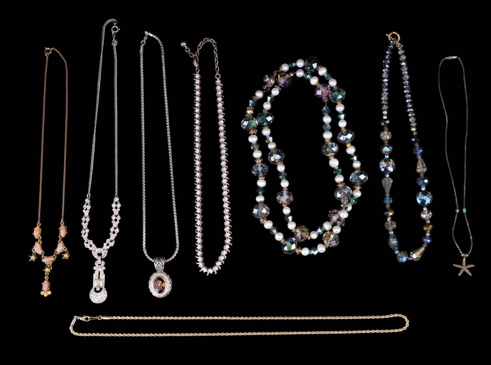 Rhinestone and Faceted Bead Necklaces: A collection of necklaces featuring a Native style liquid silver necklace with starfish charm, a gold tone faux Mexican opal necklace, a silver tone Art Deco style rhinestone necklace, gold tone rope 