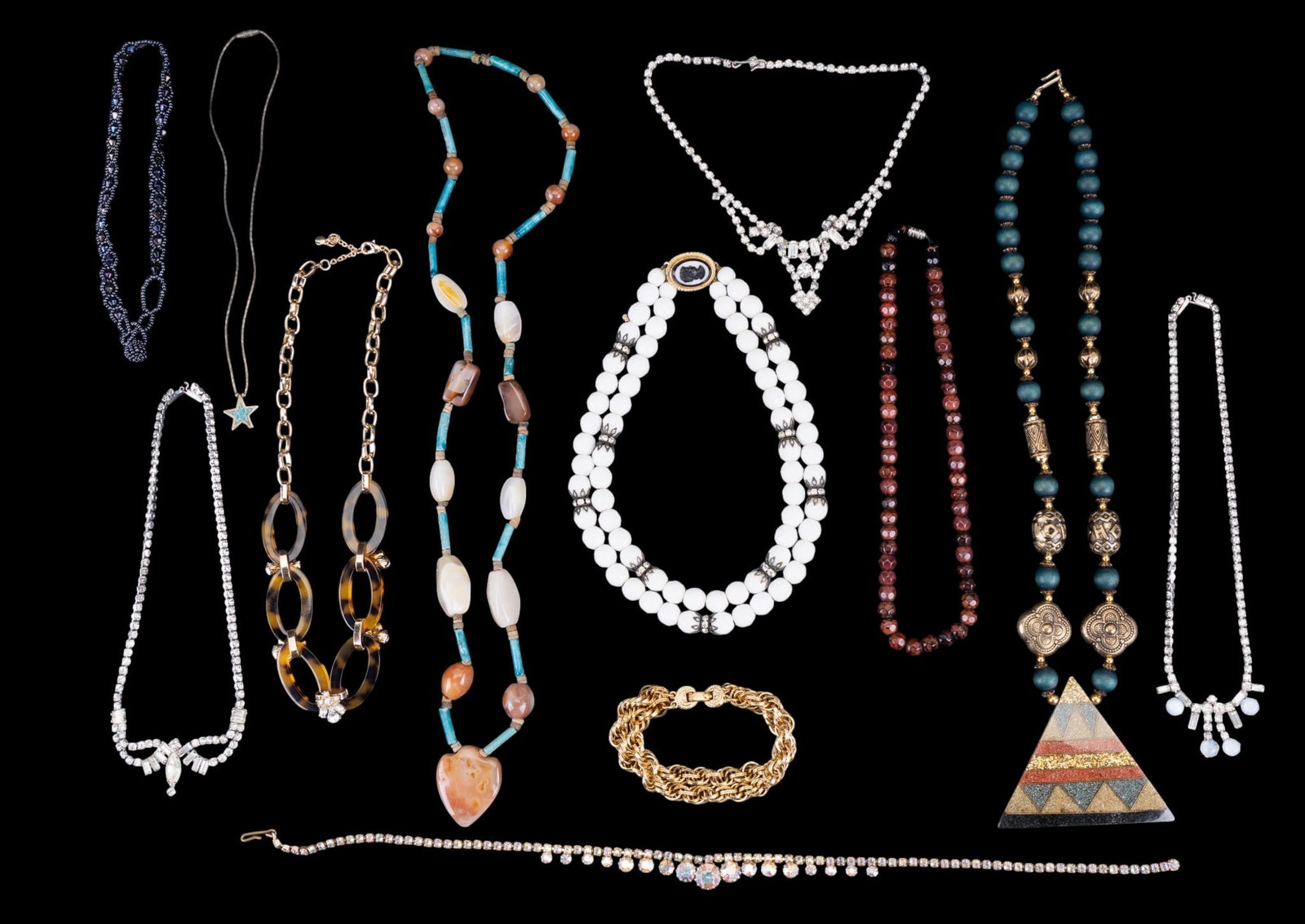 Rhinestone, Beaded, and Other Necklaces: A collection of necklaces including a vintage white facet cut bead necklace with cameo style box clasp, a liquid silver style necklace with turquoise chip inlay star pendant, a natural polished banded