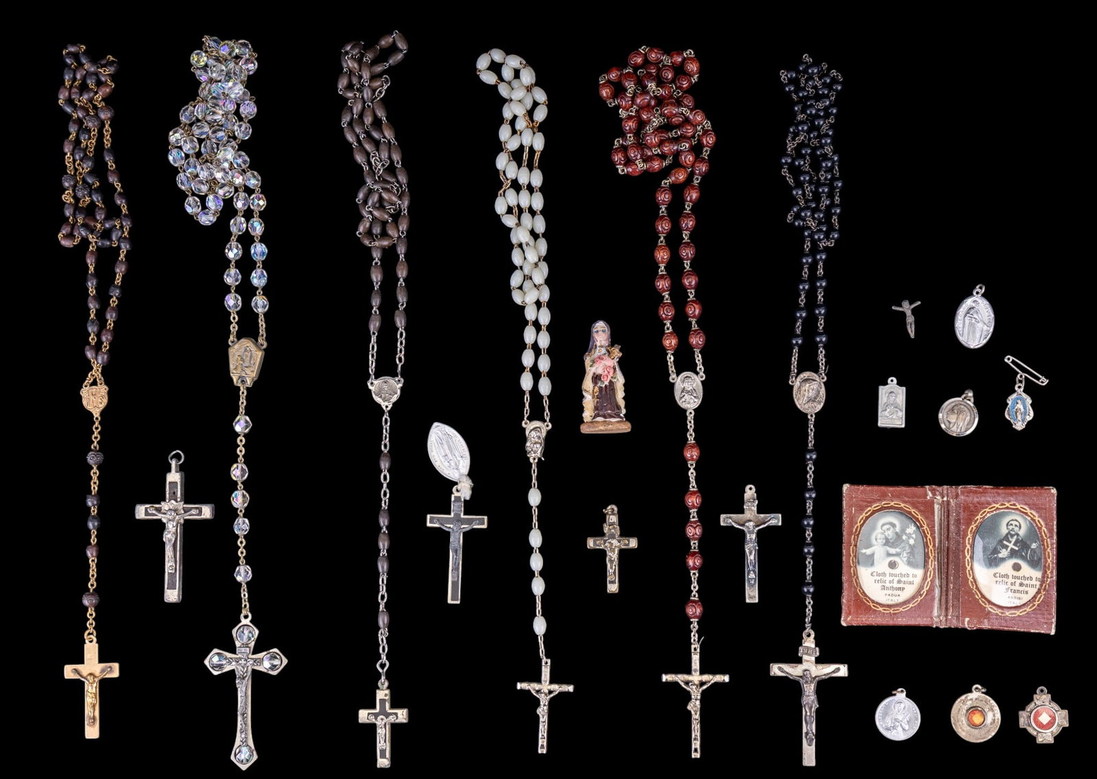 Rosaries, Relic Cloth, and Prayer Medallions: A collection of vintage Rosaries, swatches of Relic cloth pendants, a Rosary case, and prayer medallions.