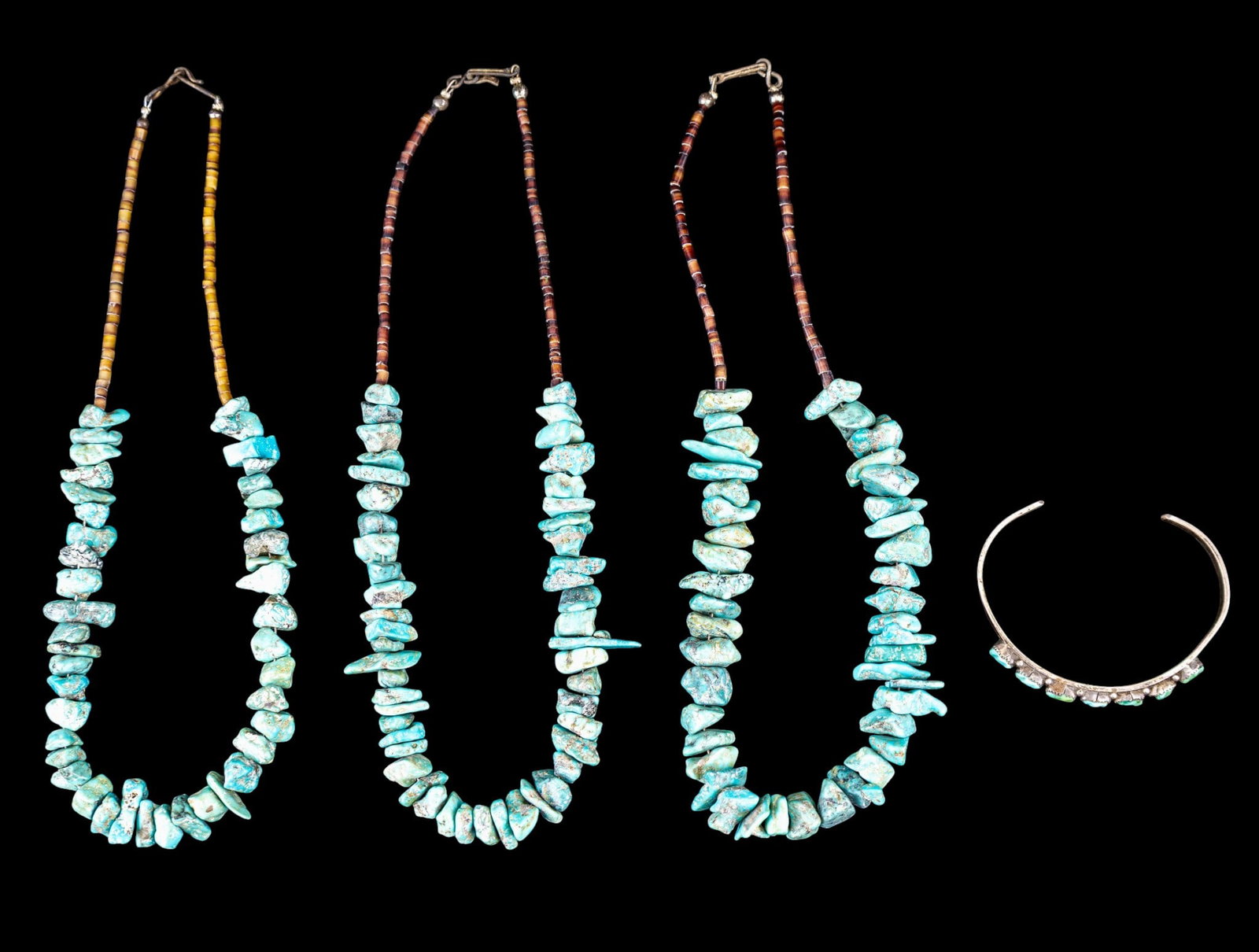 Natural Turquoise Jewelry: A collection of natural turquoise nugget jewelry including three heishi and turquoise nugget necklaces, and a silver tone cuff bracelet set with natural turquoise chunks, signed.