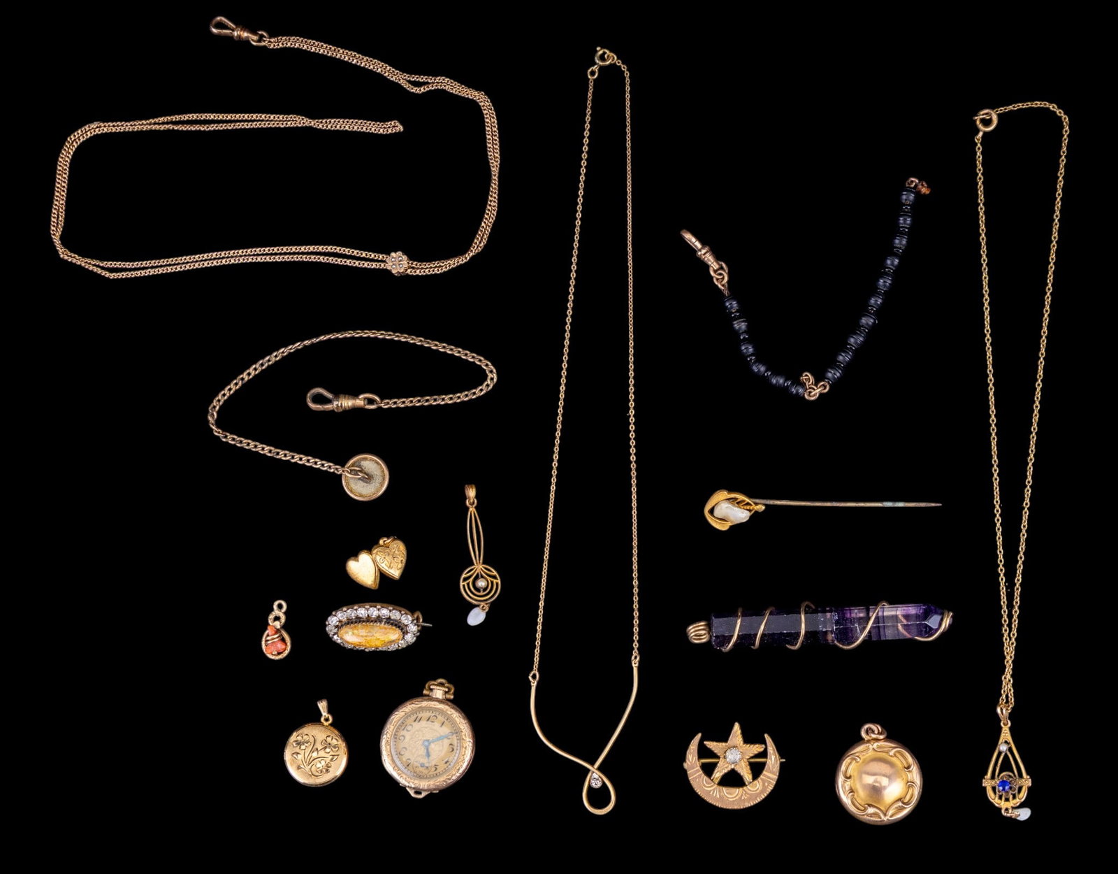 Victorian Gold Filled Jewelry: A collection of Victorian gold filled jewelry including a sun and moon etched brooch, pocket watch fobs, pendants featuring pearl, coral, and rhinestones, stick pin, wire wrapped amethyst, an Elgin 15