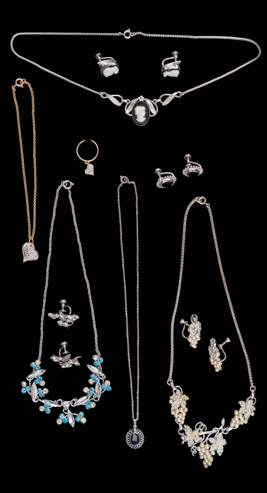 Sterling Silver Jewelry Sets: A collection of sterling silver jewelry sets including a gold tone anklet and toe ring with heart shaped charms, a cameo style necklace with matching screw back earrings, a clear and sky blue rhinesto
