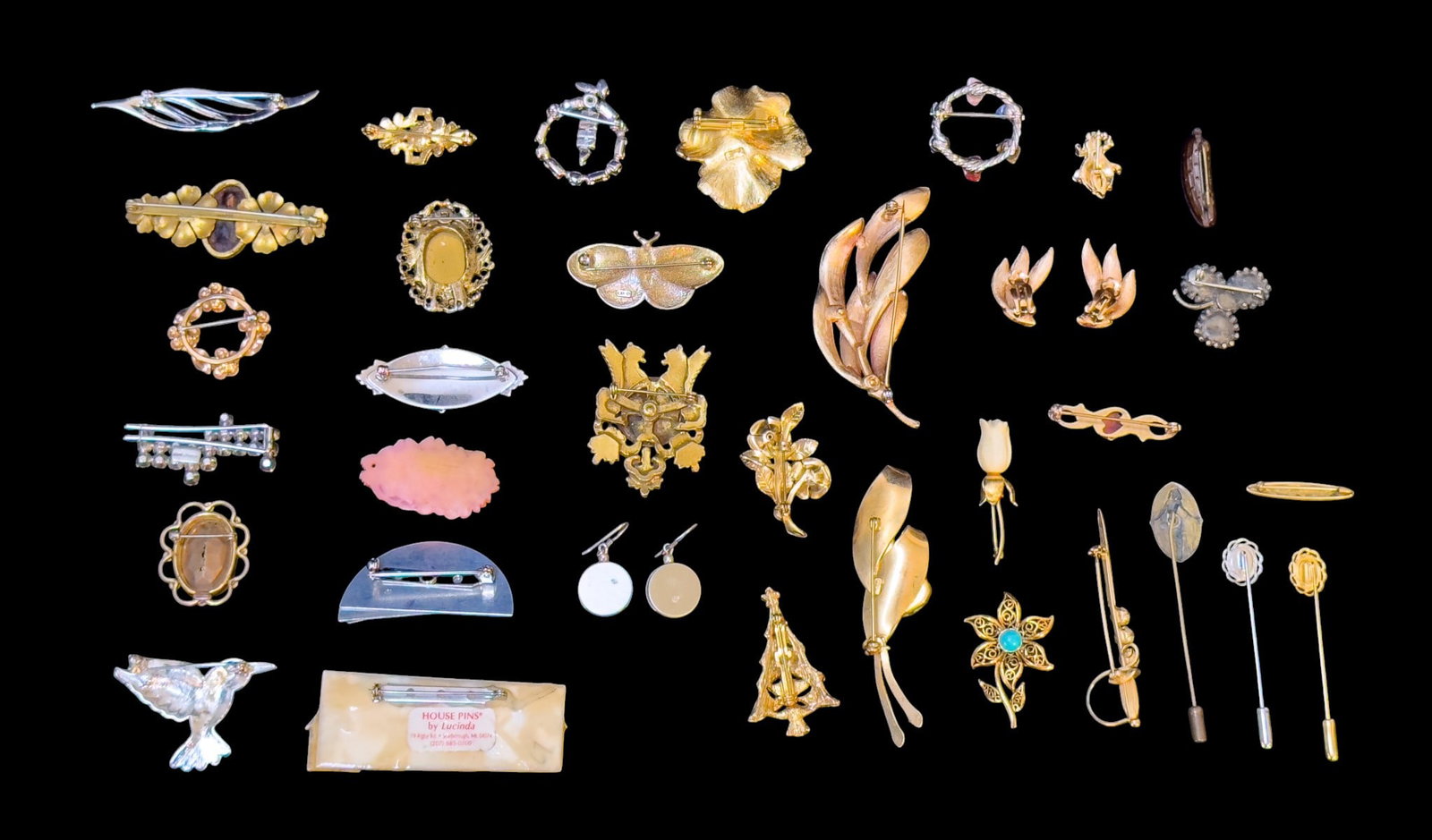 Trifari and Other Vintage Designer Brooches: A collection of vintage brooches including a silver tone wreath style with natural stone chunks, a modern silver tone brooch and matching earring set signed 'JRE', a marcasite hummingbird, a fine Art 
