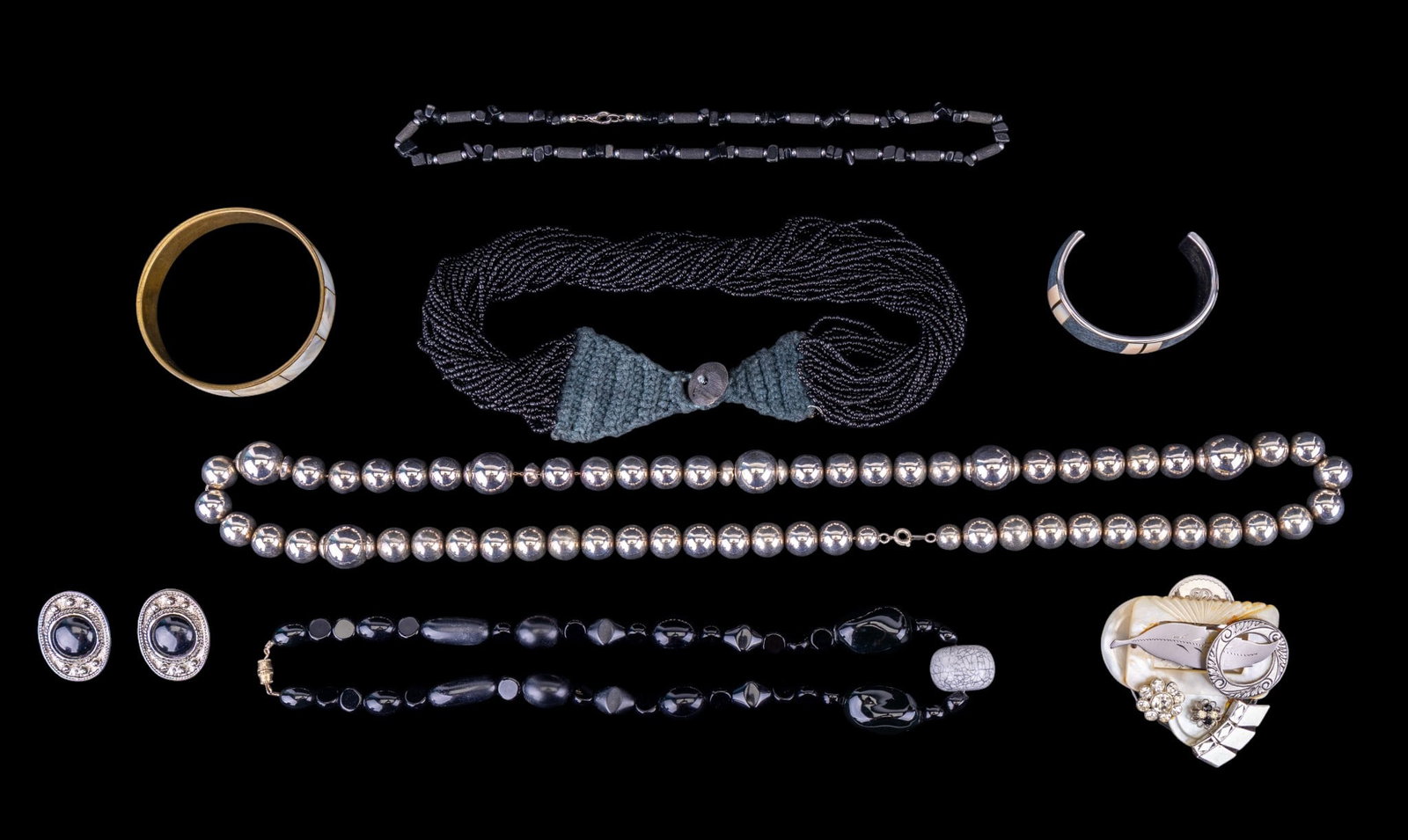 Black and Silver Tone Jewelry: Necklaces, shell cuff bracelets, clip earrings, and a collage pin fashioned out of vintage components.