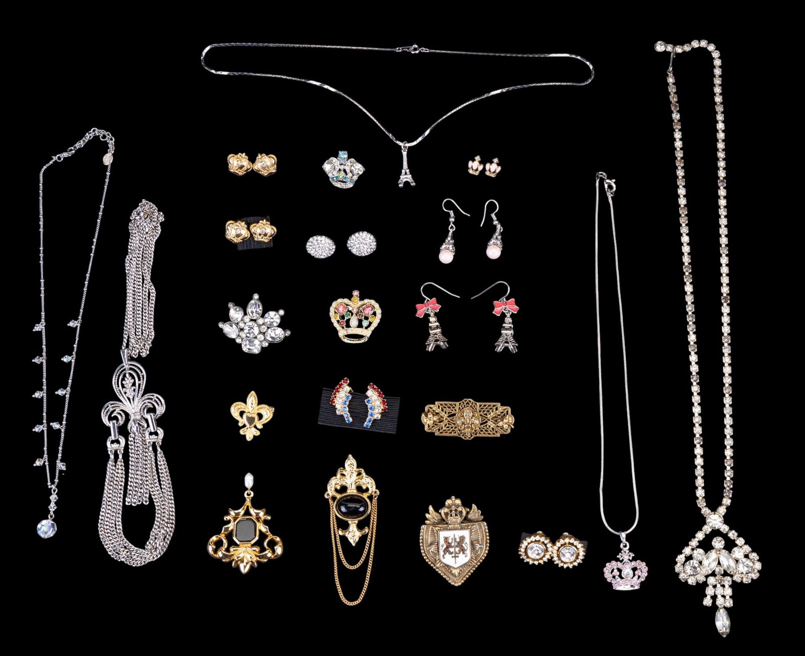 Crown & Fleur-De-Lis Jewelry: Costume jewelry featuring crown pins, earrings, and necklace; Fuer-de-lis inspired necklace and pins; Eiffel Tower earrings and necklace, and a vintage pair of clip pronged rhinestone earrings with th