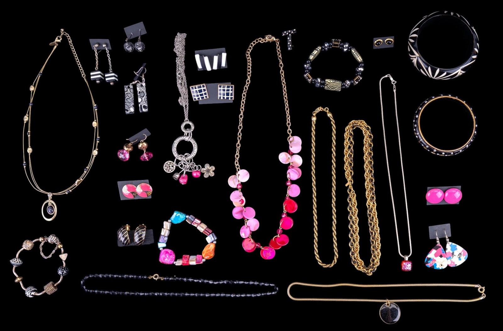 Black, White, & Pink Jewelry: Twenty-five pieces of black, white, and pink costume jewelry featuring a pair of Fender guitar pick earrings, a Trifari black and gold tone chain necklace, a Kremetz silver tone snake chain necklace
