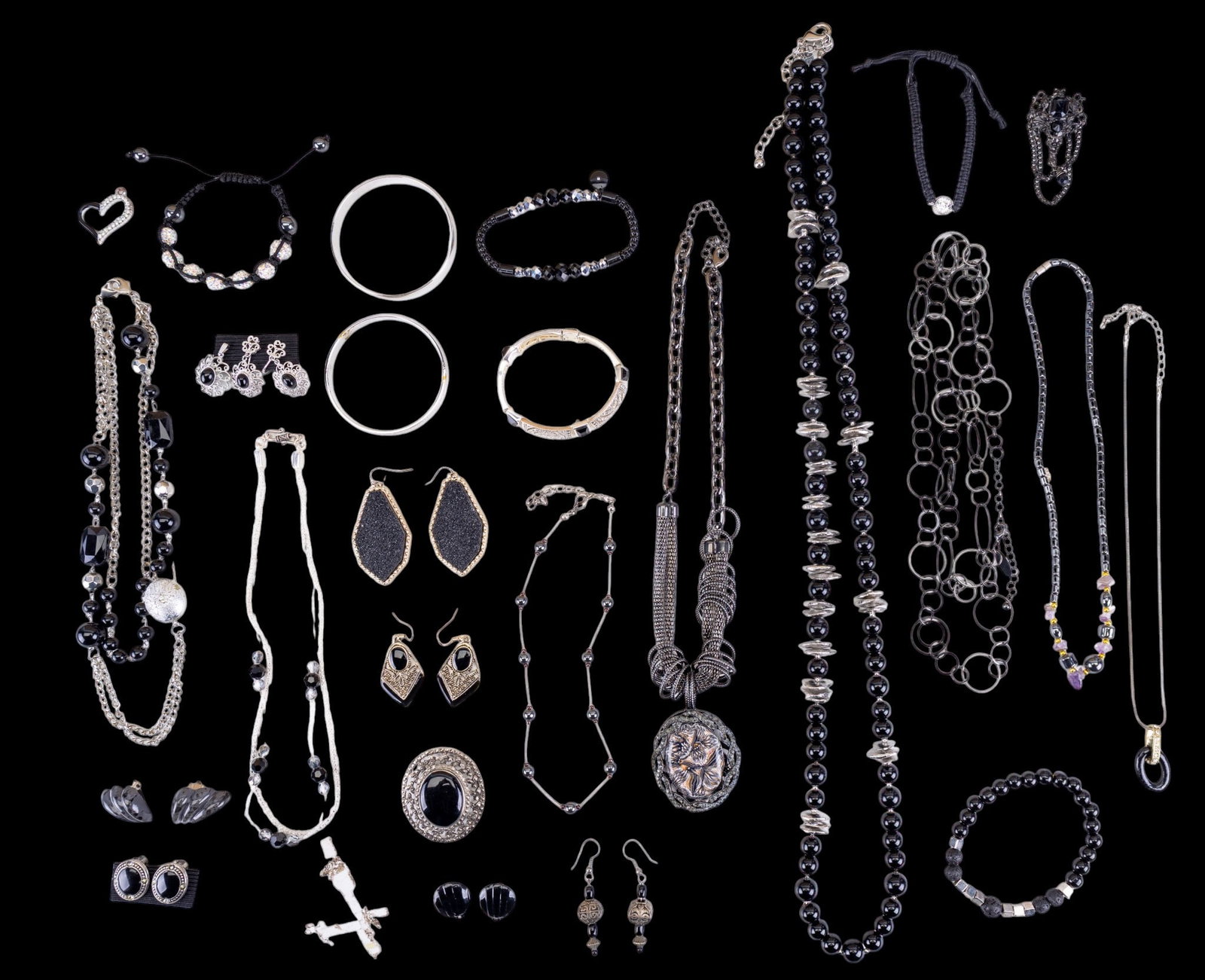 Silver Tone and Black Costume Jewelry: Twenty-five pieces of silver tone and black costume jewelry including pins, necklaces, bracelets, and earrings (both pierced and clip). Items featured are a braided wax cord bracelet with a sterling a