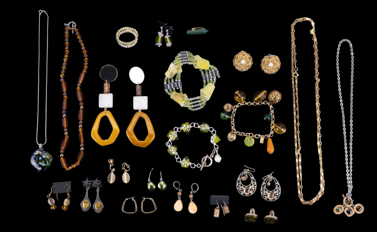 Costume Jewelry: Green and amber colored costume jewelry featuring a sterling 16" necklace with a fused glass pendant, a pair of Monet pressed glass flower pattern clip earrings, a glass heart bracelet with a fresh wa