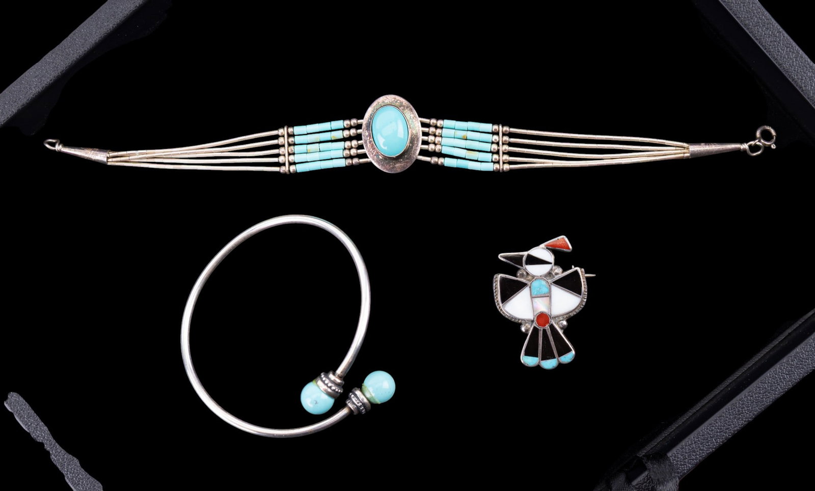 Native American Styled Jewelry: This group features a Native American Zuni multi-stone inlaid 1 1/4" Thunderbird sterling silver pin, a multi-strand 7 1/2" sterling and turquoise bracelet, and a silver costume bangle with turquoise 