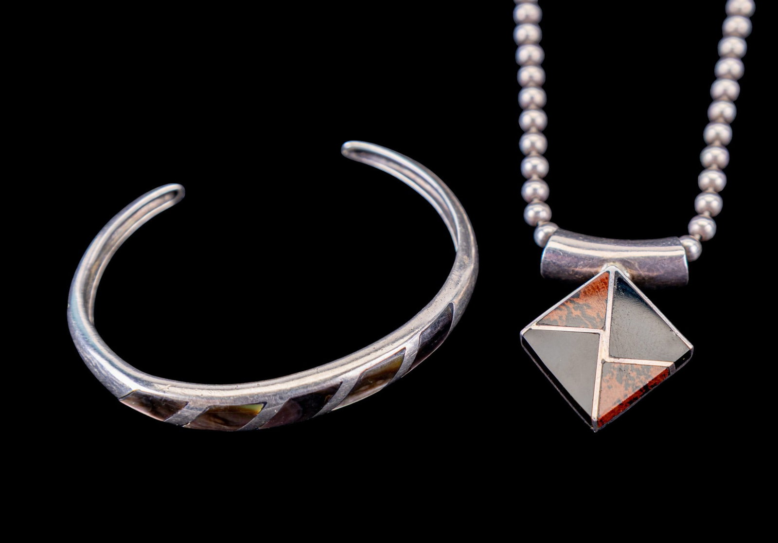 Sterling Cuff Bracelet & Taxco Necklace: A fine sterling silver cuff bracelet featuring abalone inlay and a Taxco Mexican sterling pendant with onyx and brown jasper inlay on an Italian sterling ball chain. Chain measures approx. 9" on the d