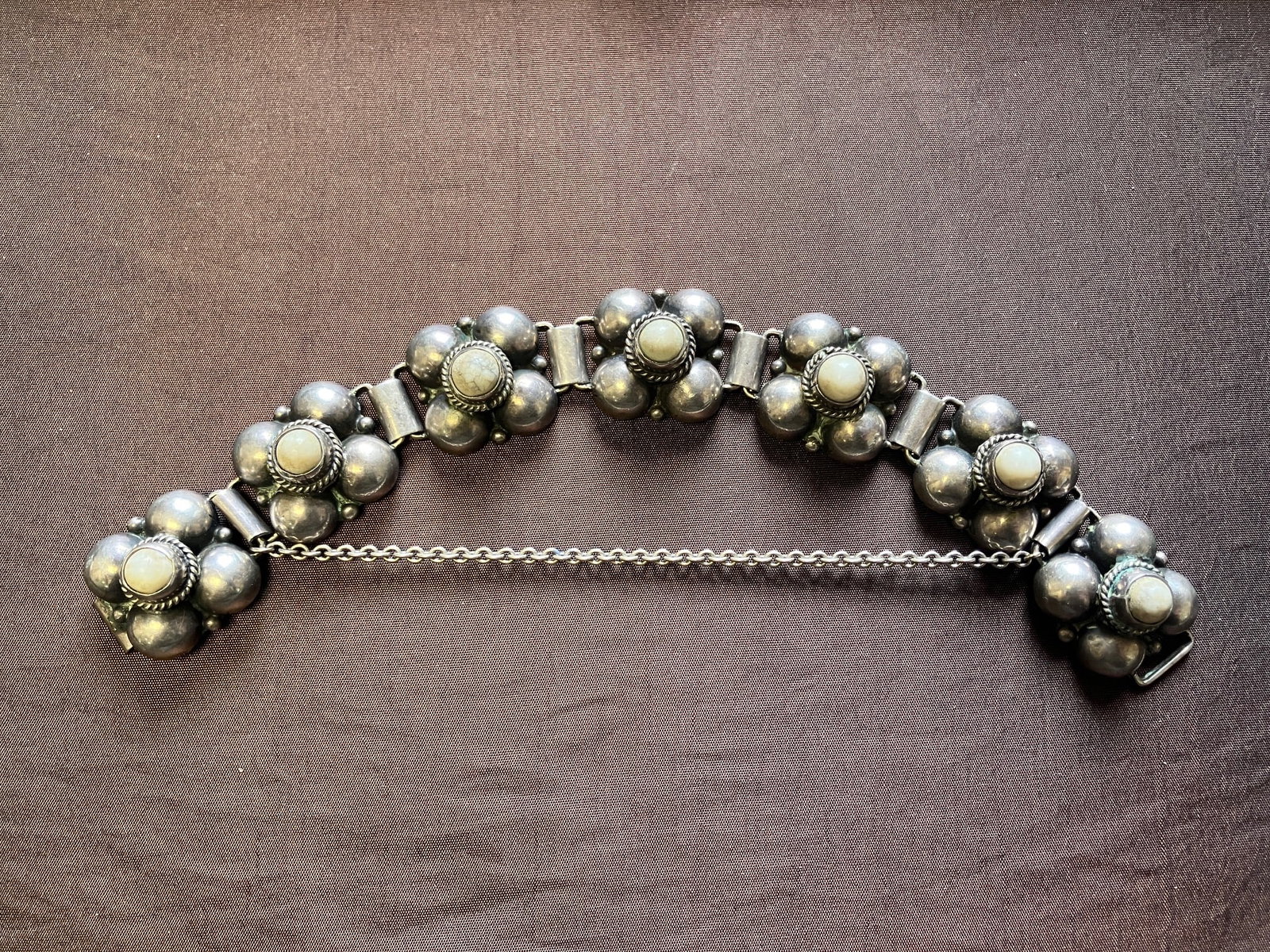 Mexican Silver and Quartz Panel Bracelet: A quality Mexican silver panel bracelet featuring white quartz cabochons. Approx 7" L with safety chain. Weight approx 42 grams.