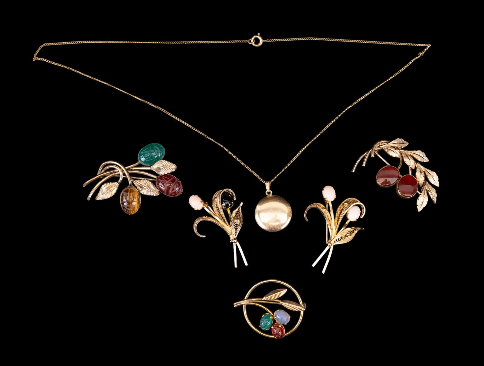 Victorian Gold Filled Jewelry: A collection of Victorian gold filled jewelry featuring filigree brooches with onyx, pink coral, carnelian, and scarab cabochons, a mother pearl locket necklace, chain measures approx. 9" on the drop.