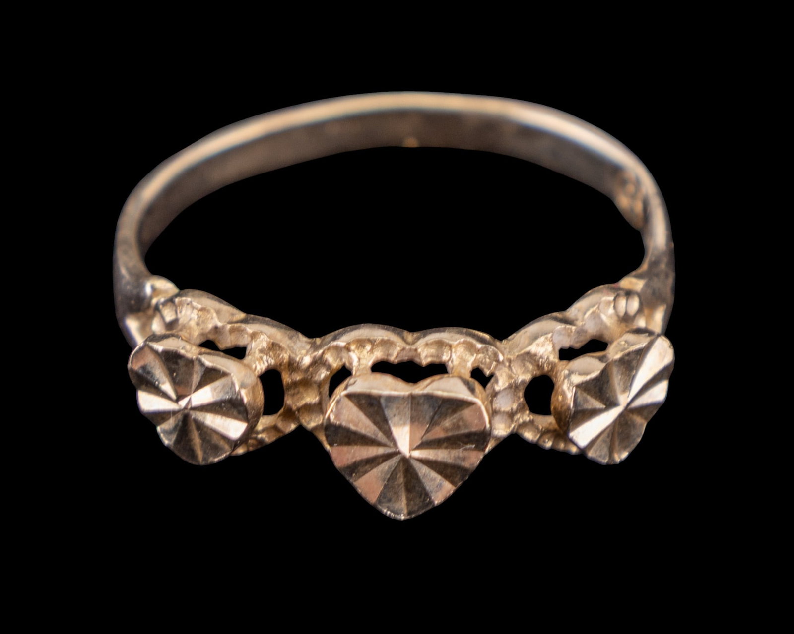 10K Gold Raised Triple Heart Ring: A 10k yellow gold marked ring with 3 patterned hearts. Weight is approx. 1.78 grams. Ring size 7.