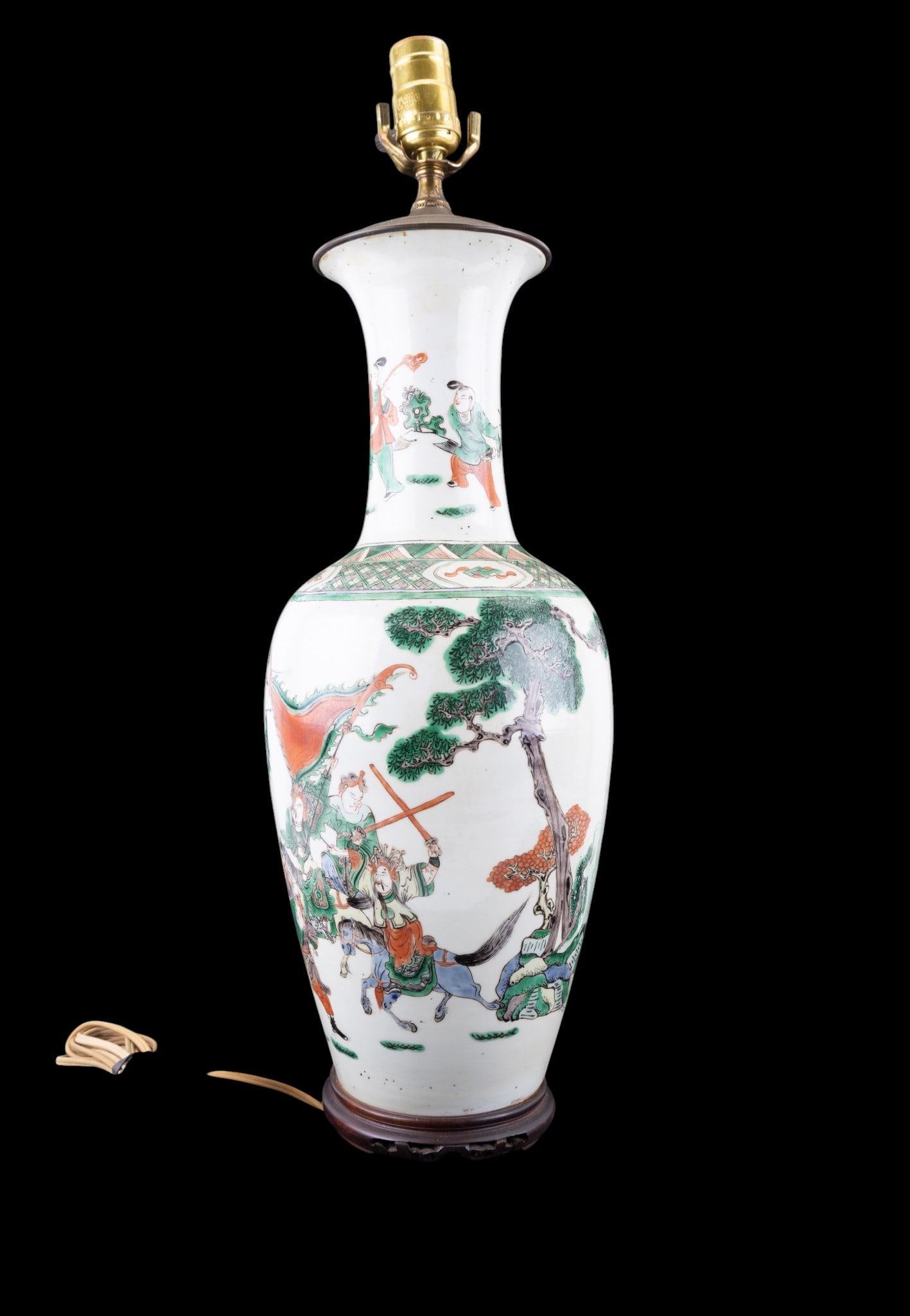 Chinese Wucai Large Porcelain Vase/Lamp: Large Chinese wucai porcelain vase/lamp with carved wooden base, depicting a battle scene along with geometric designs under neck. Measures approx. 23.5" high, 7.5" diameer at widest point. Porcelain