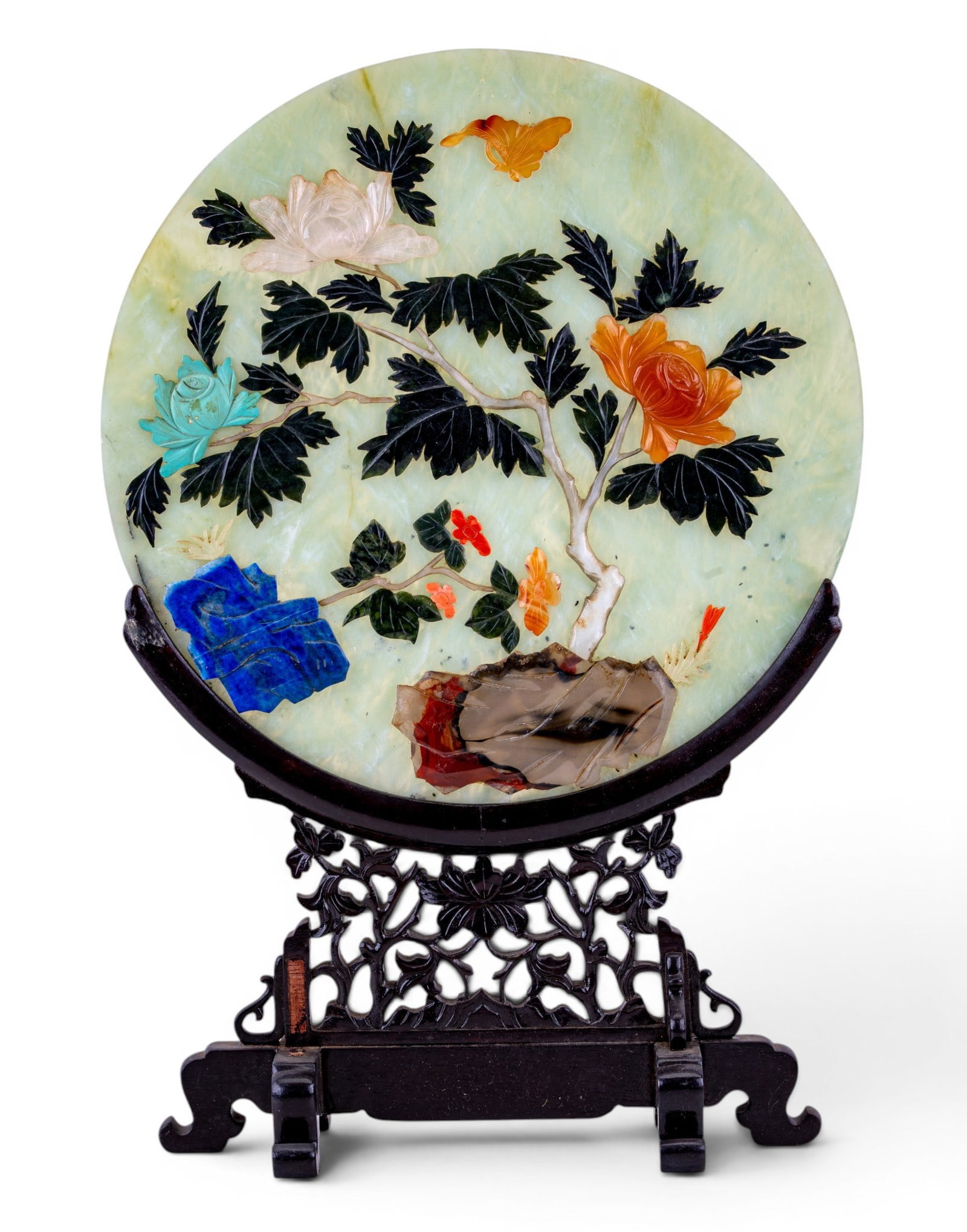 Chinese Hardstone Inlaid Plaque w/ Stand: Circular Chinese hardstone plaque featuring carved and inlaid tree, butterfly, and rockwork decoration composed of lapis lazuli, carnelian, agate, and other hardstone. Mounted in a carved hardwood sta