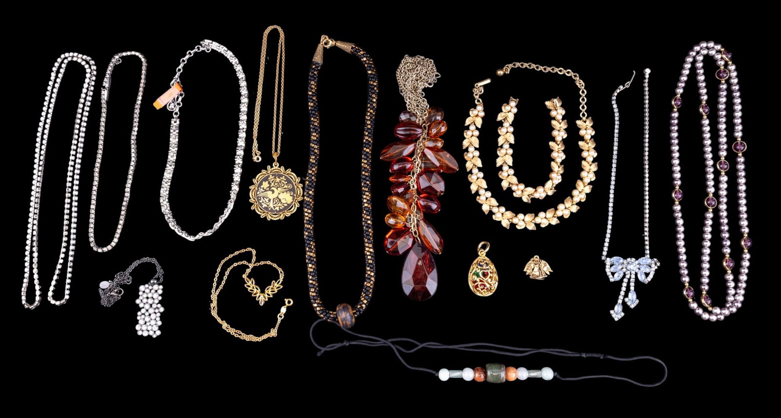 Coro and Other Vintage Costume Necklaces: A collection of vintage costume necklaces including a silver tone interlocking link Coro necklace, a Cookie Lee black tone metal and rhinestone pendant, a vintage faux pearl and gold leaf motif choker